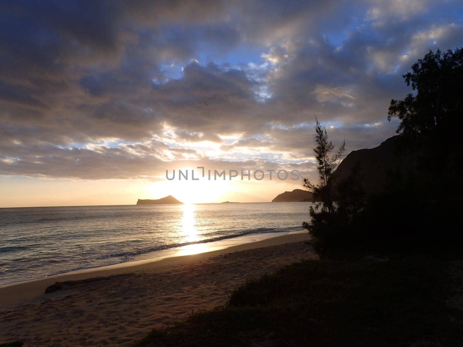 Early Morning Sunrise on Waimanalo Beach over Rock Island bursting through the clouds by EricGBVD