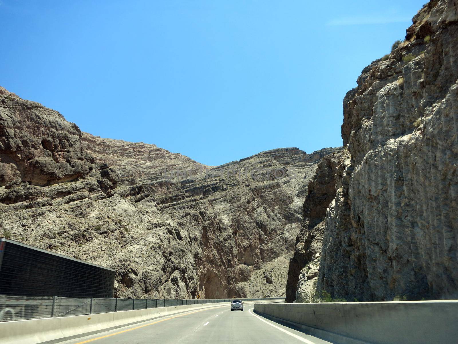 Highway Road  with SUV car in front through Rocky Mountains of Utah USA.