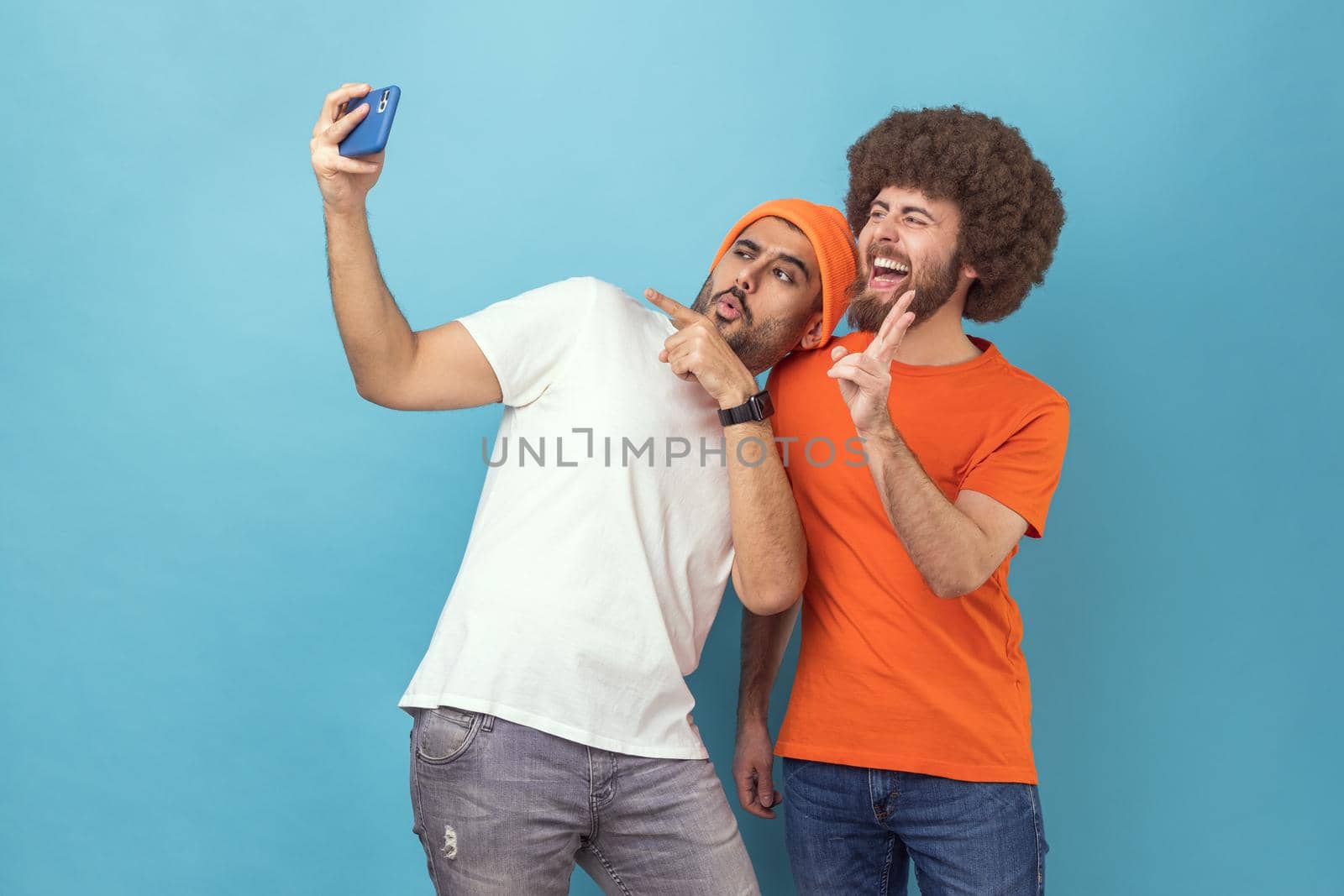 Two men pointing to camera and showing v sign while having video call or broadcasting livestream. by Khosro1