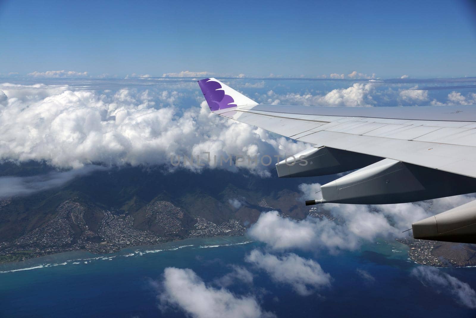  Wing of Hawaiian Airlines plane flying in the air above Honolulu by EricGBVD