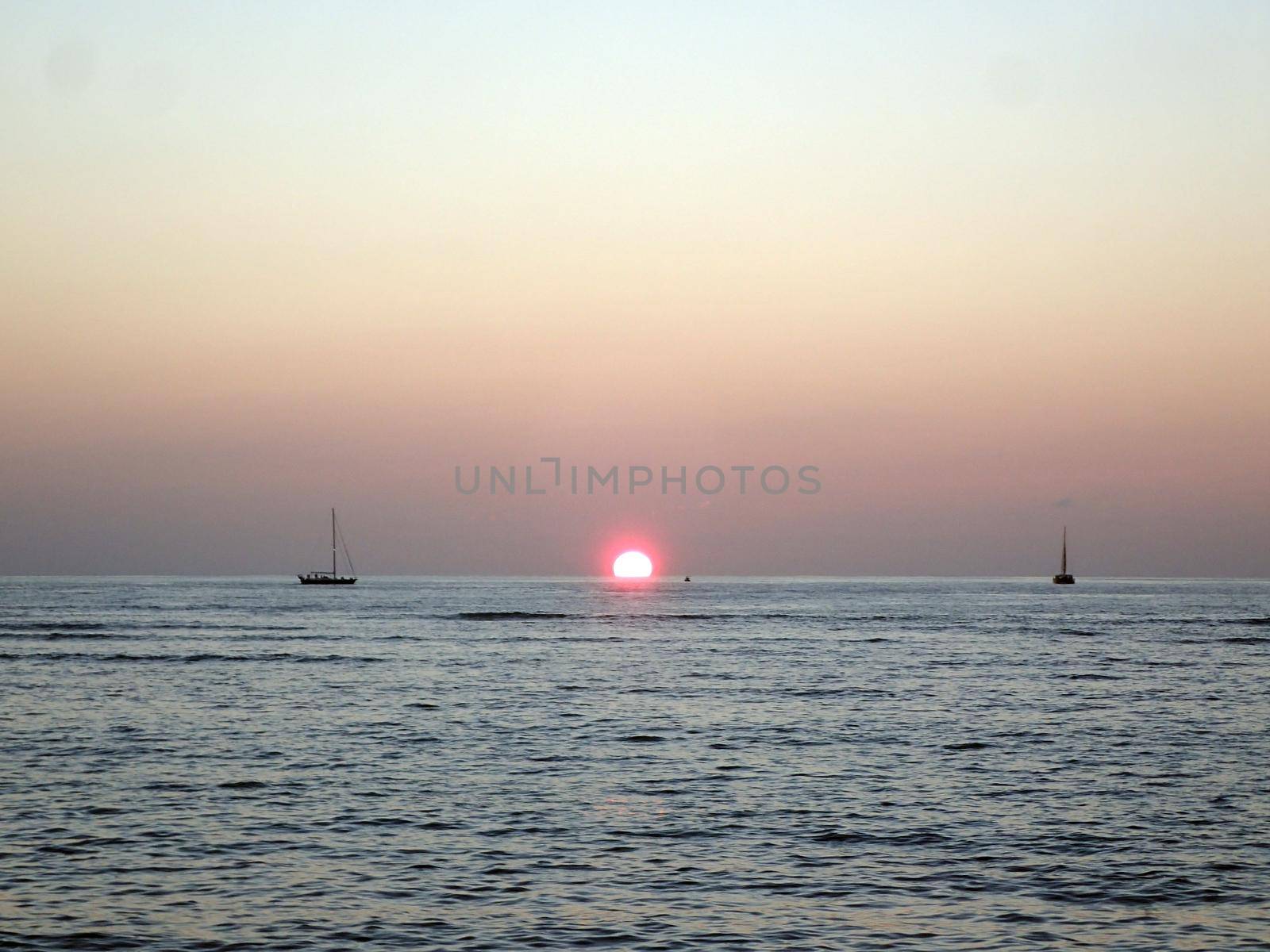 Sunset over Waikiki Ocean with boats in water on Oahu, Hawaii.  January 2015.