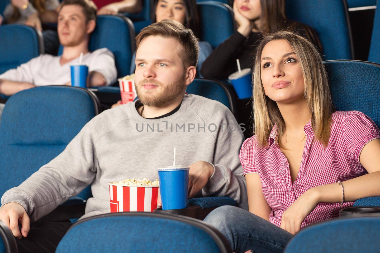 Date night. Shot of a young cheerful couple at the cinema