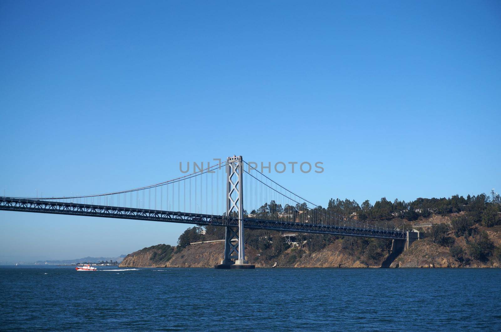 Bay Bridge, yerba buena island and boat sailing under on a nice day in California.                               