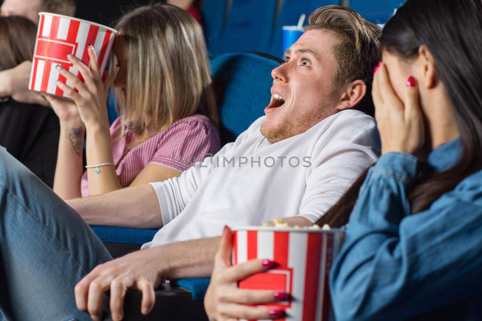 Terrifying moment. Shot of group of friends watching movies looking terrified at the local cinema
