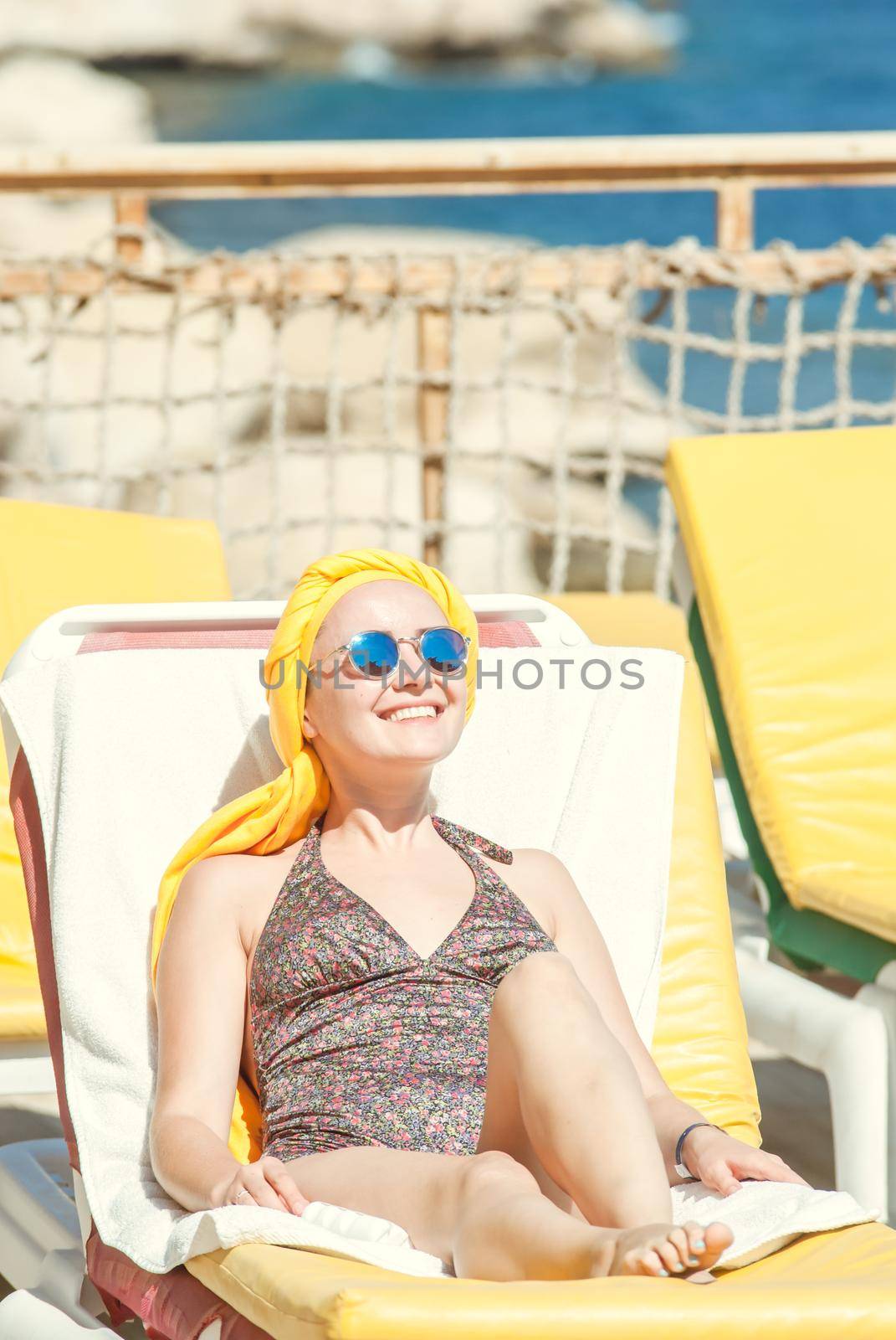 young woman sunbathing at the see terrase in retro swimwear