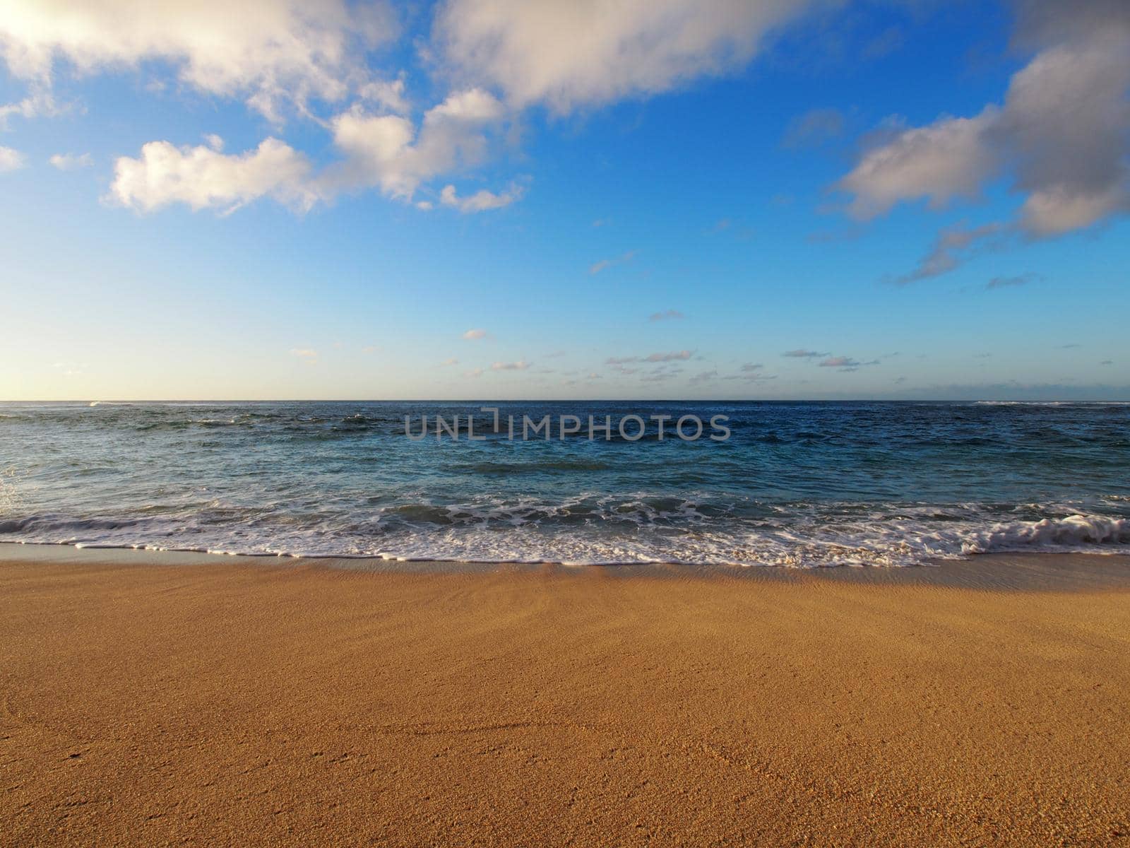 Waves lap on Sunset Beach at Dusk on a clear day on Oahu, Hawaii.