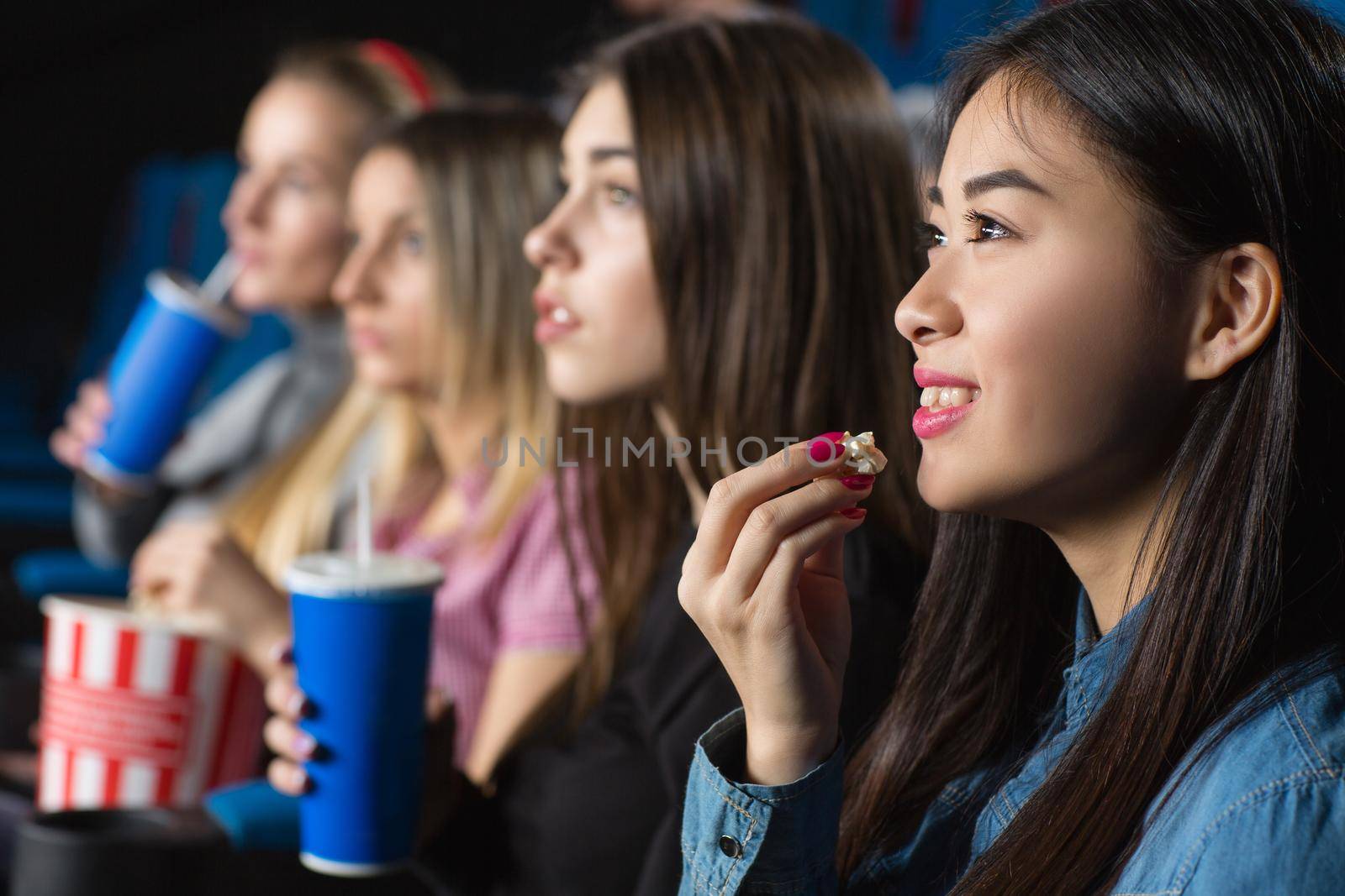 Favorite leisure. Beautiful young asian woman smiling cheerfully eating popcorn watching movies with her girlfriends