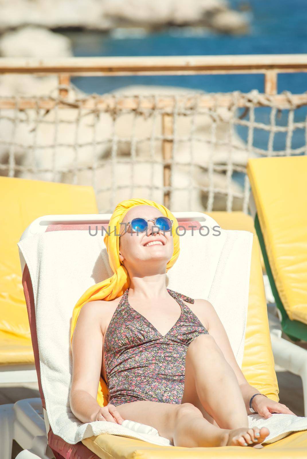 young woman sunbathing at the see terrase in retro swimwear