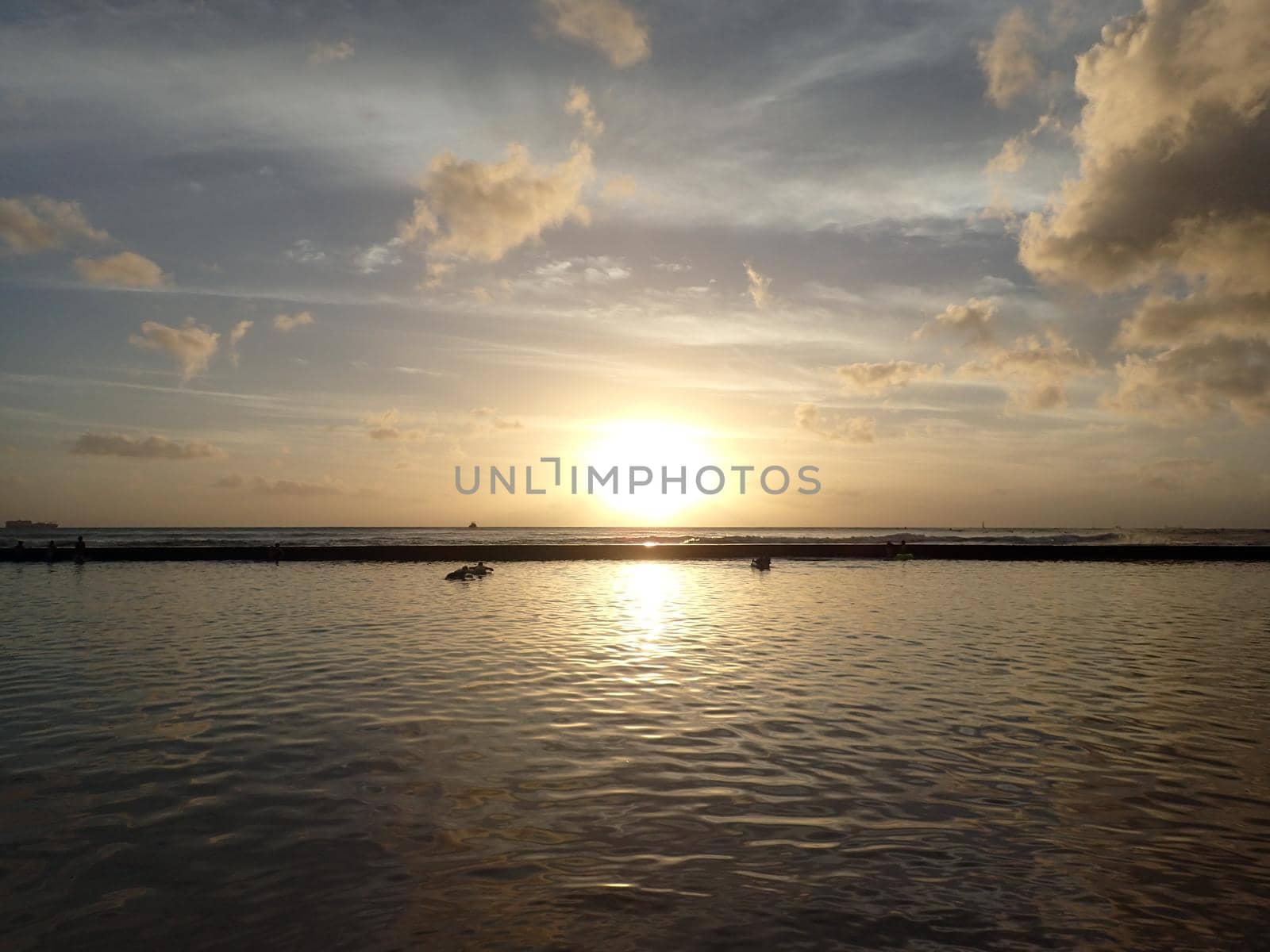 Dramatic Sunset on waters of Waikiki with boats on Horizon on Oahu, Hawaii.