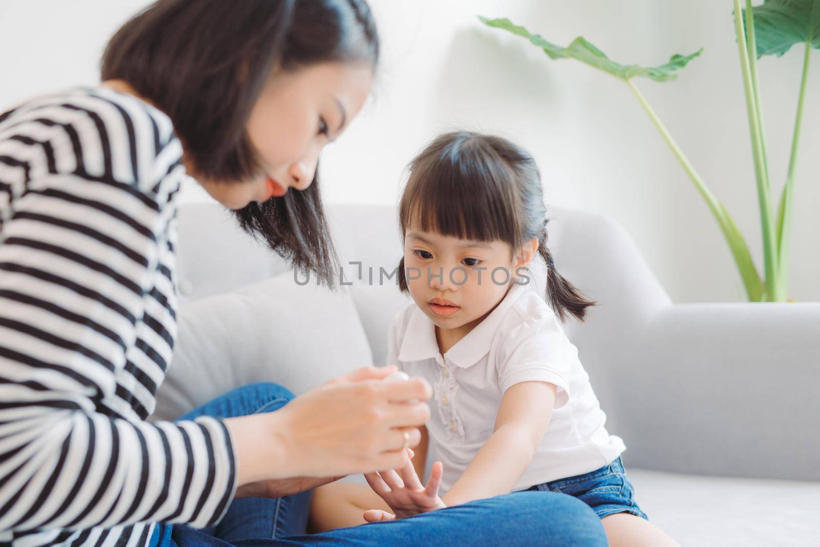 Cute daughter with mother making manicure at home by makidotvn