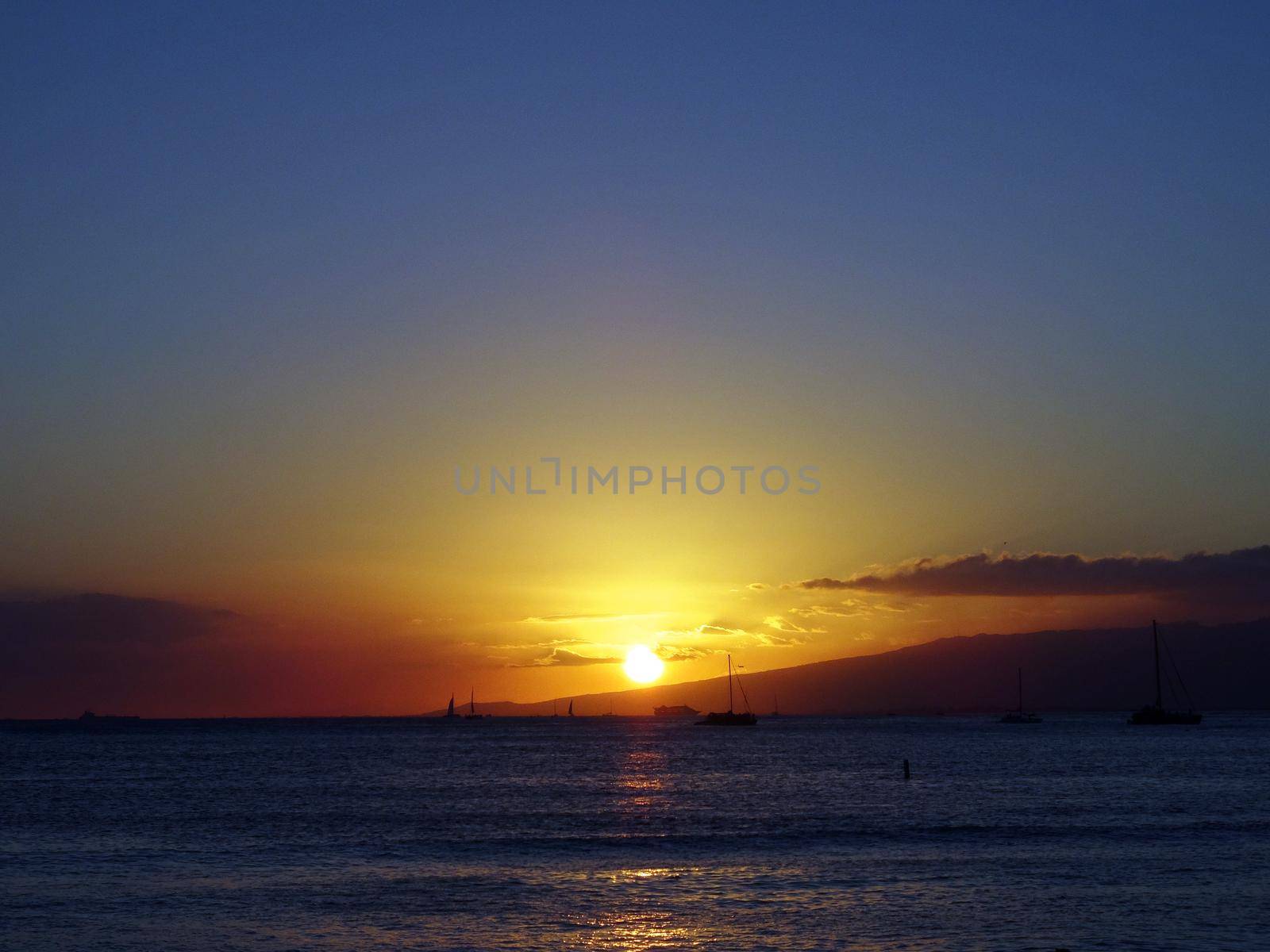 dramatic lighting as Sunsets behind Waianae mountains  by EricGBVD