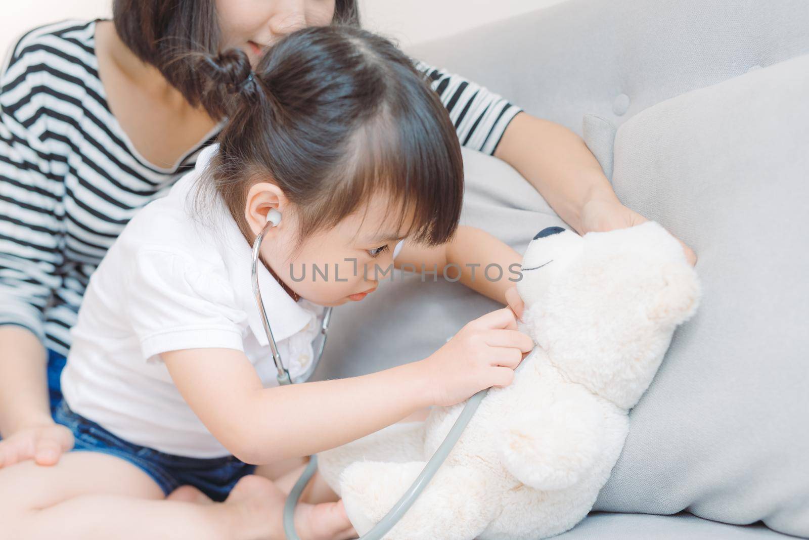 Amused little girl playing game at home