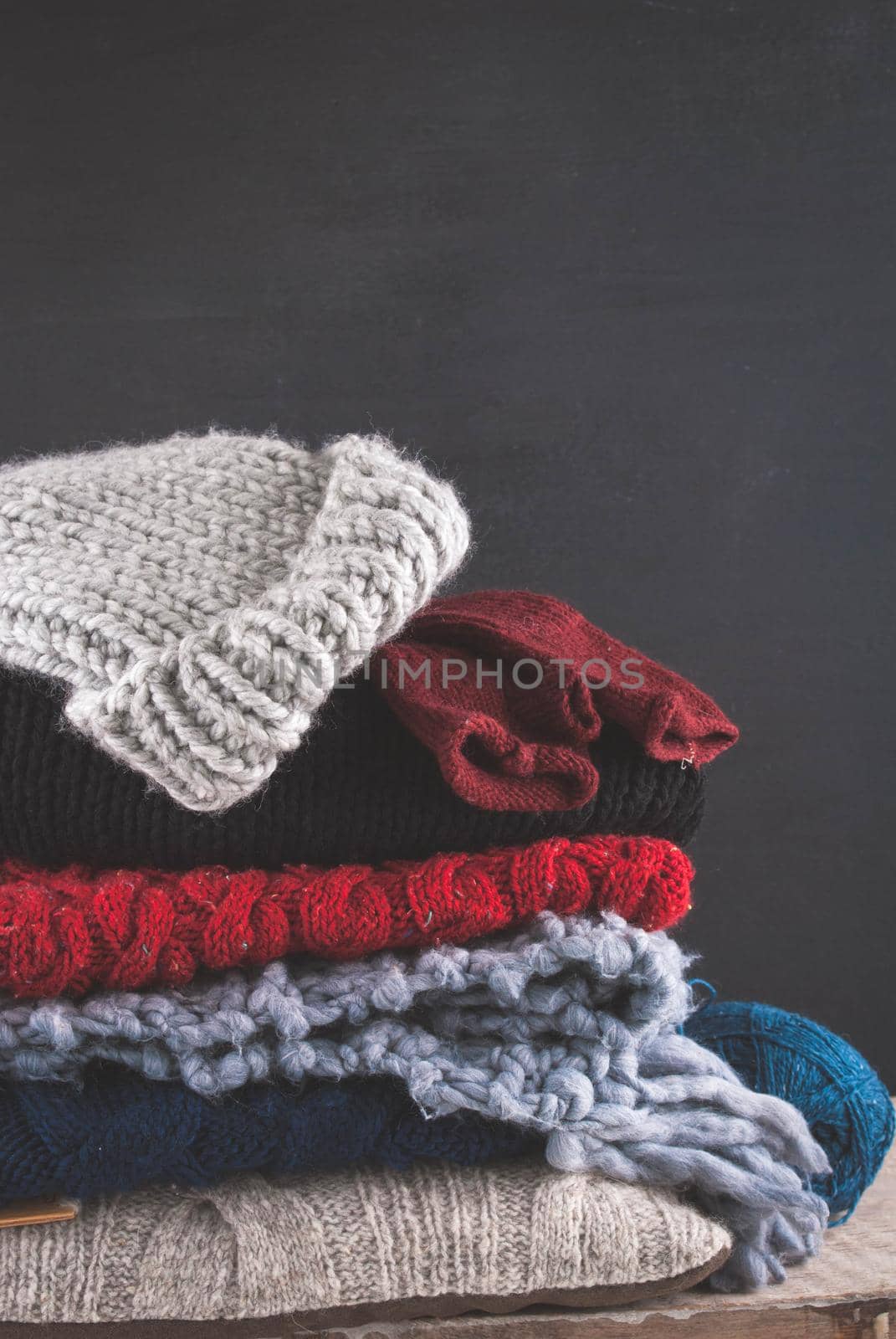 Knitted colorful and textured woven clothing on blackwooden background