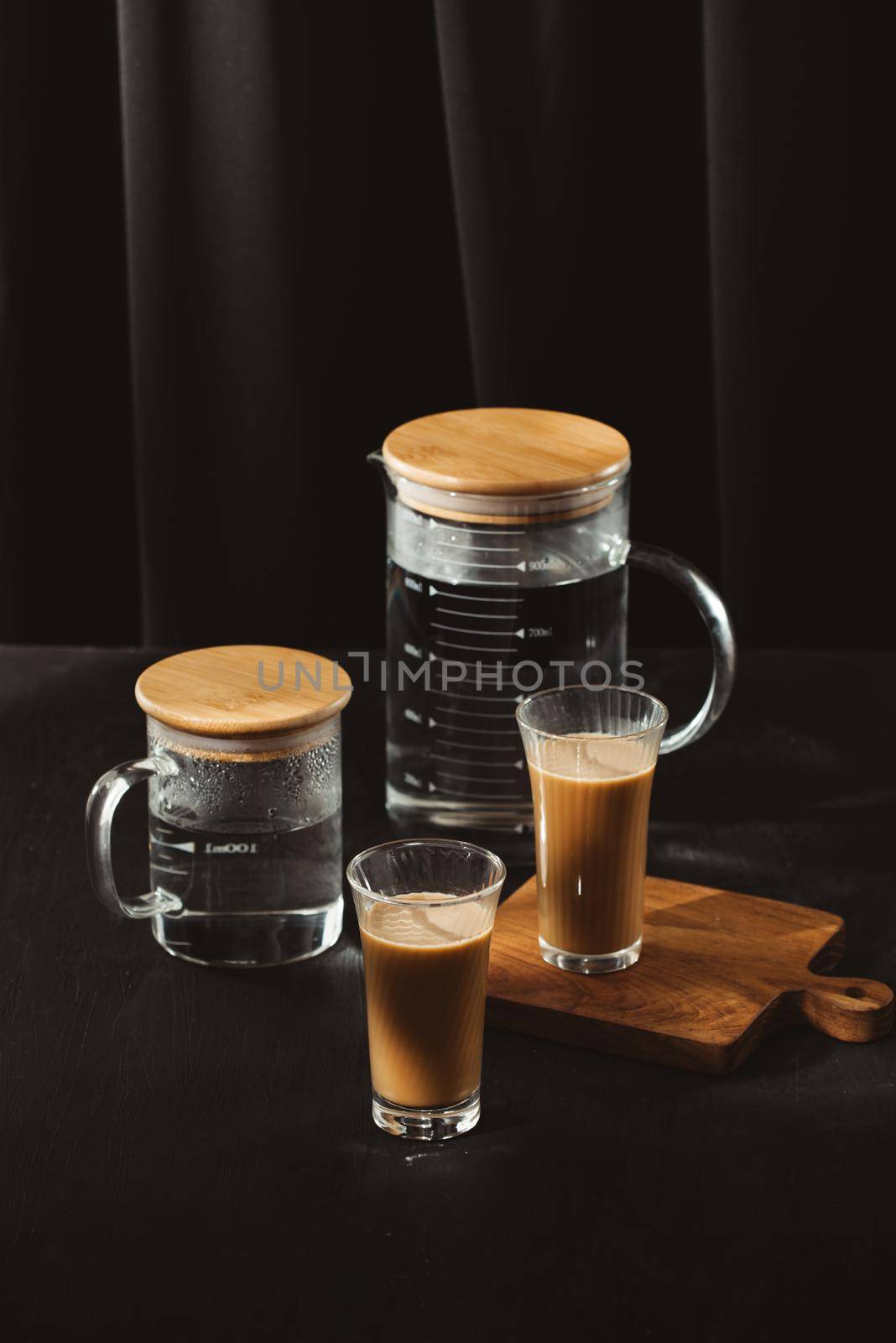 Water bottles and milk coffee glass on dark background. 