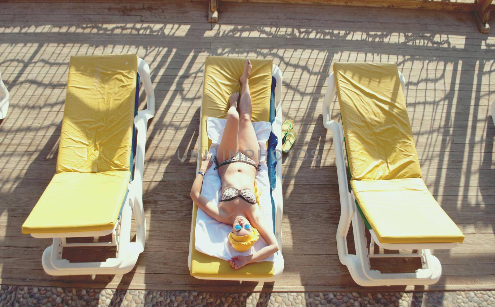 young woman sunbathing at the sea terrace by maramorosz