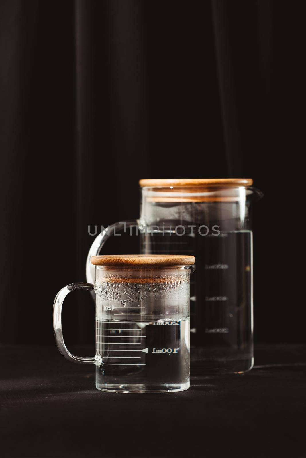 Jugs of water reflection dark background by makidotvn
