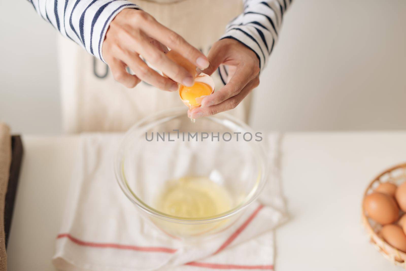 broken egg in hands with separated yolk closeup 