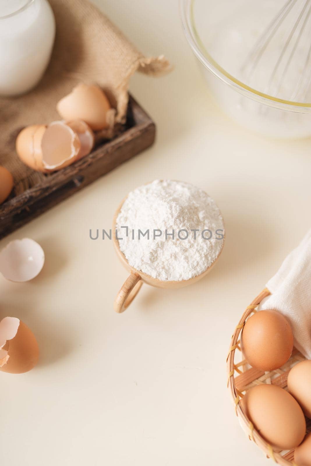 Young man's hands whisk eggs with sugar to bake fruit cake. Male cooking dough for pie on white table by makidotvn