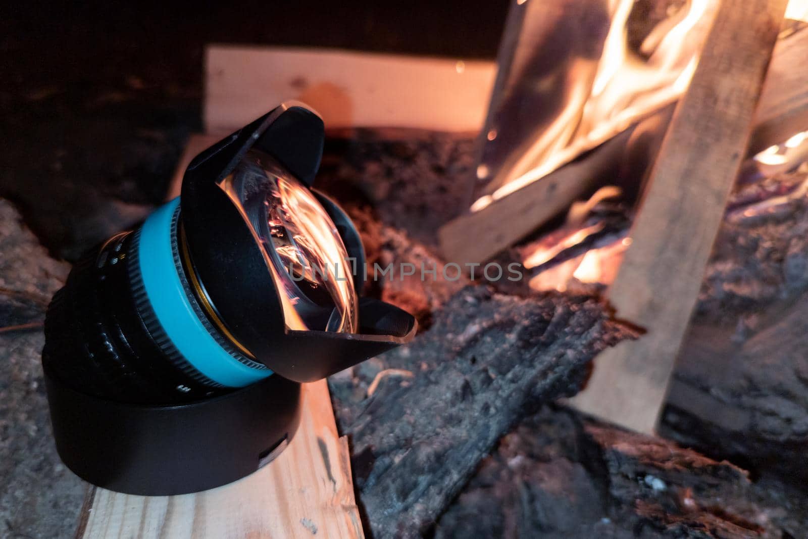 ultra-wide angle lens warming up near campfire at night to avoid condensation during following photoshoot