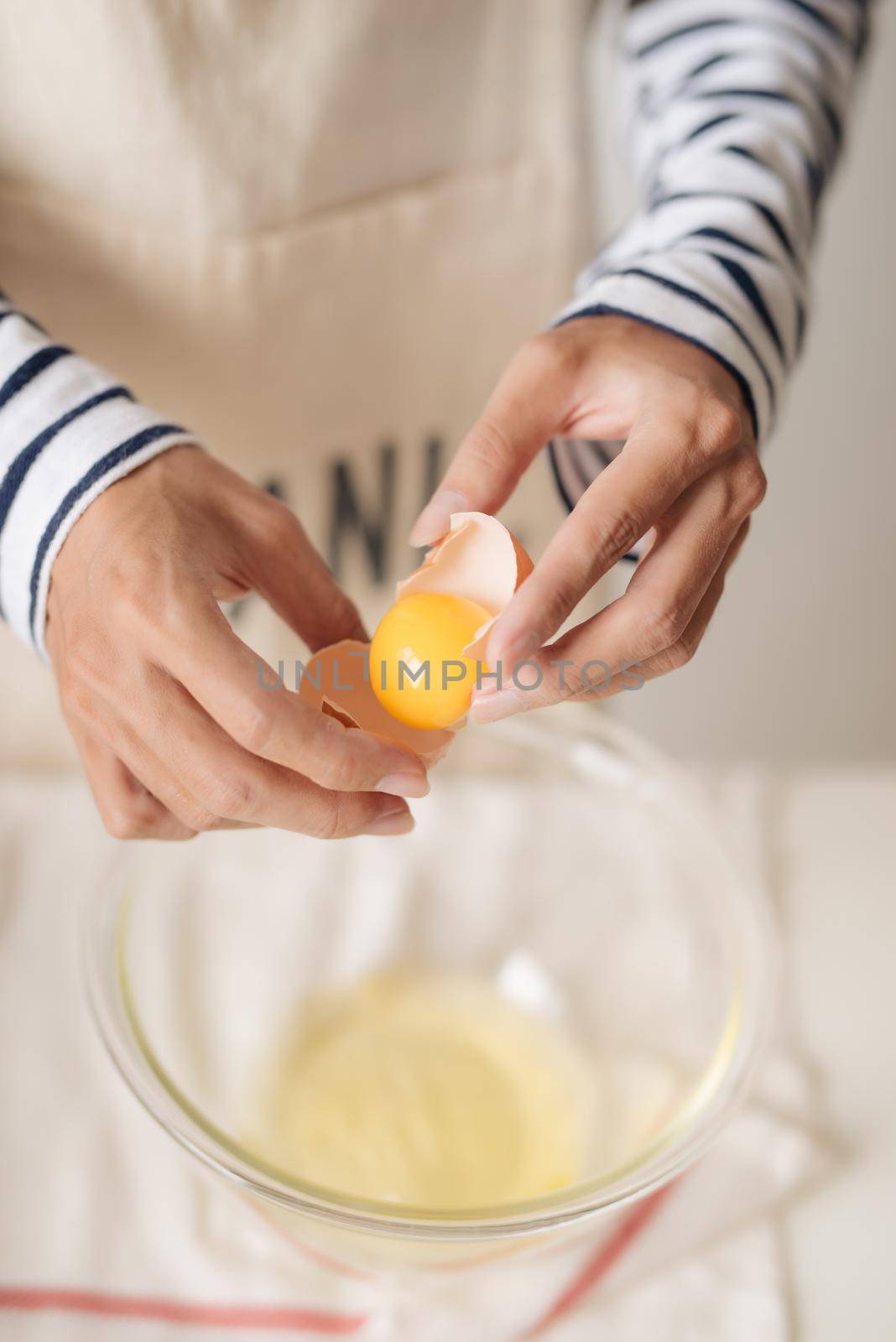 broken egg in hands with separated yolk closeup  by makidotvn