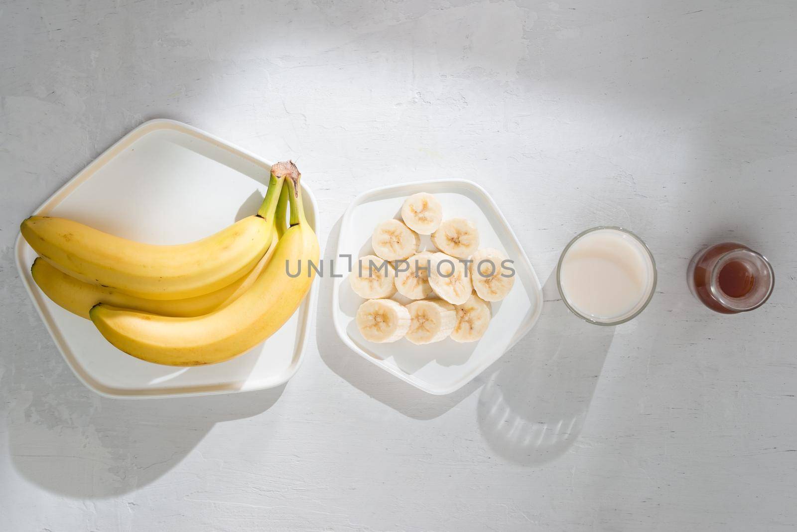 Yummy bananas and bowl with slices on wooden background