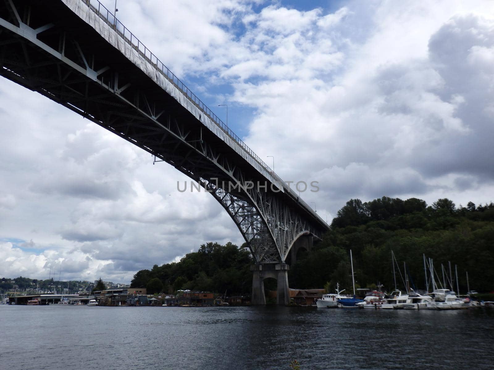 Aurora Bridge, under repair, towers over Union Lake with boats lining the shore in Seattle, Washington.