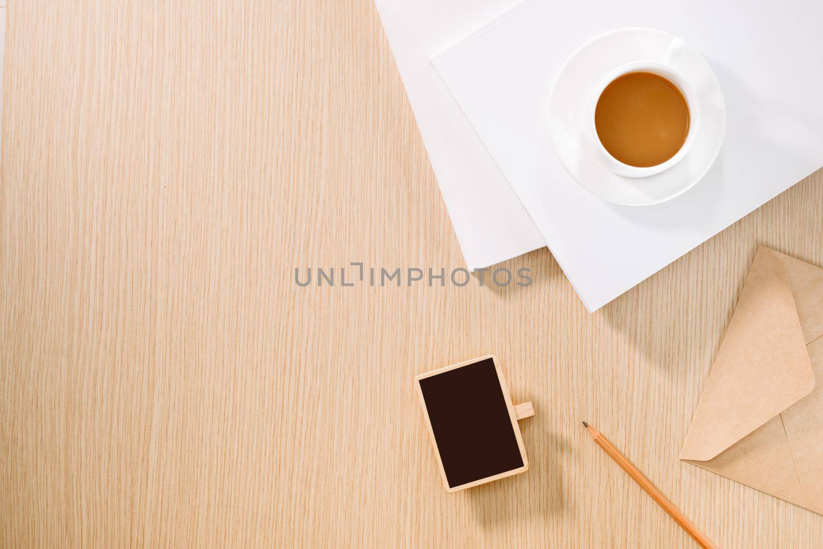 Flat lay of coffee cup, clock, pencil and a notebook. 