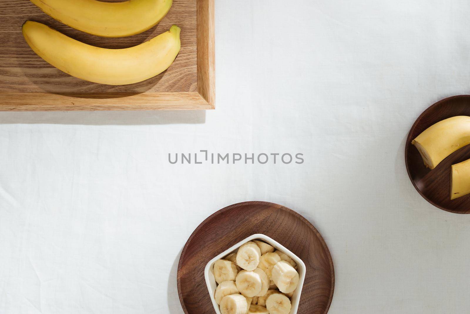 Bananas and banana pieces in a wooden plate by makidotvn