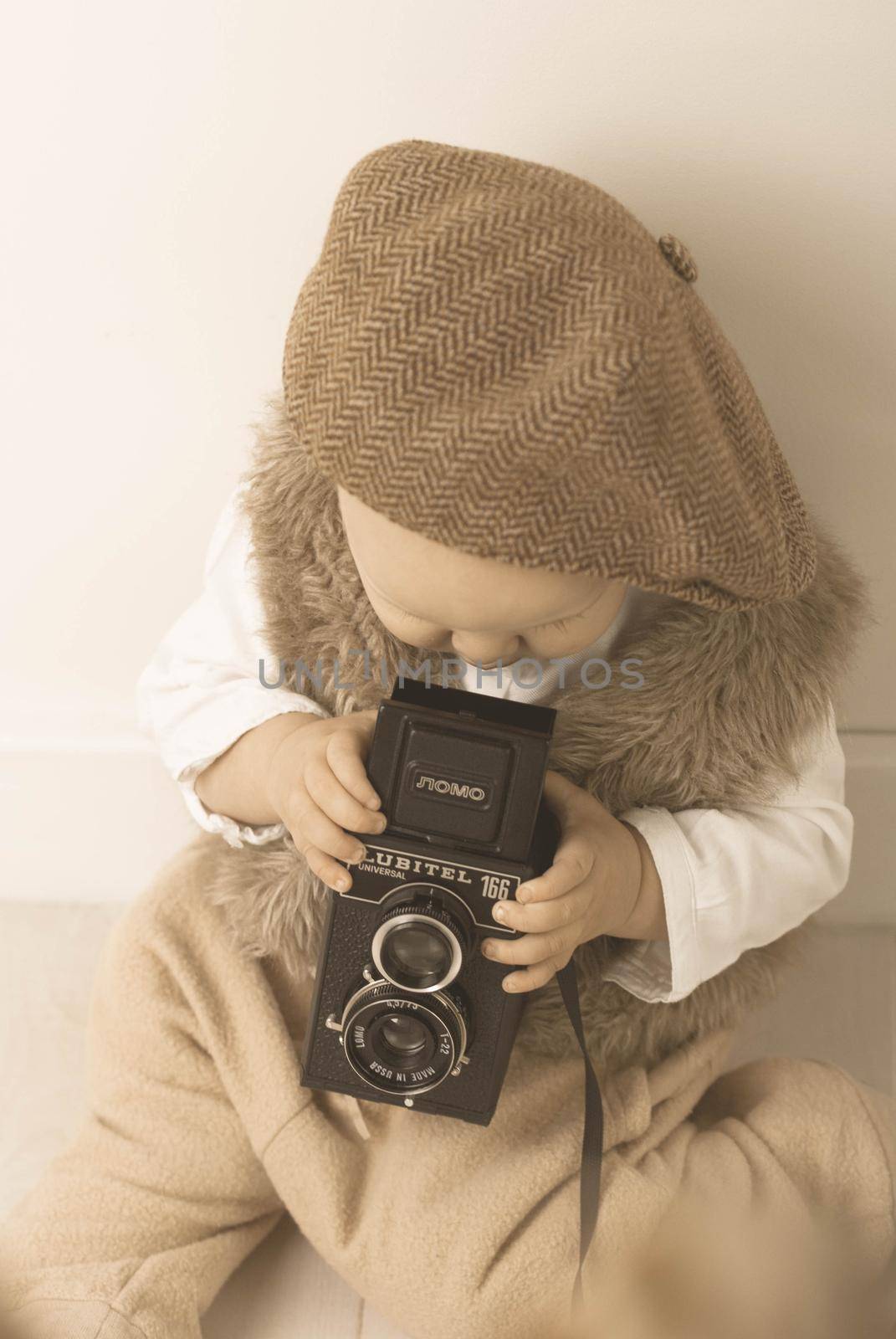 Retro styled photo with cute baby and old camera