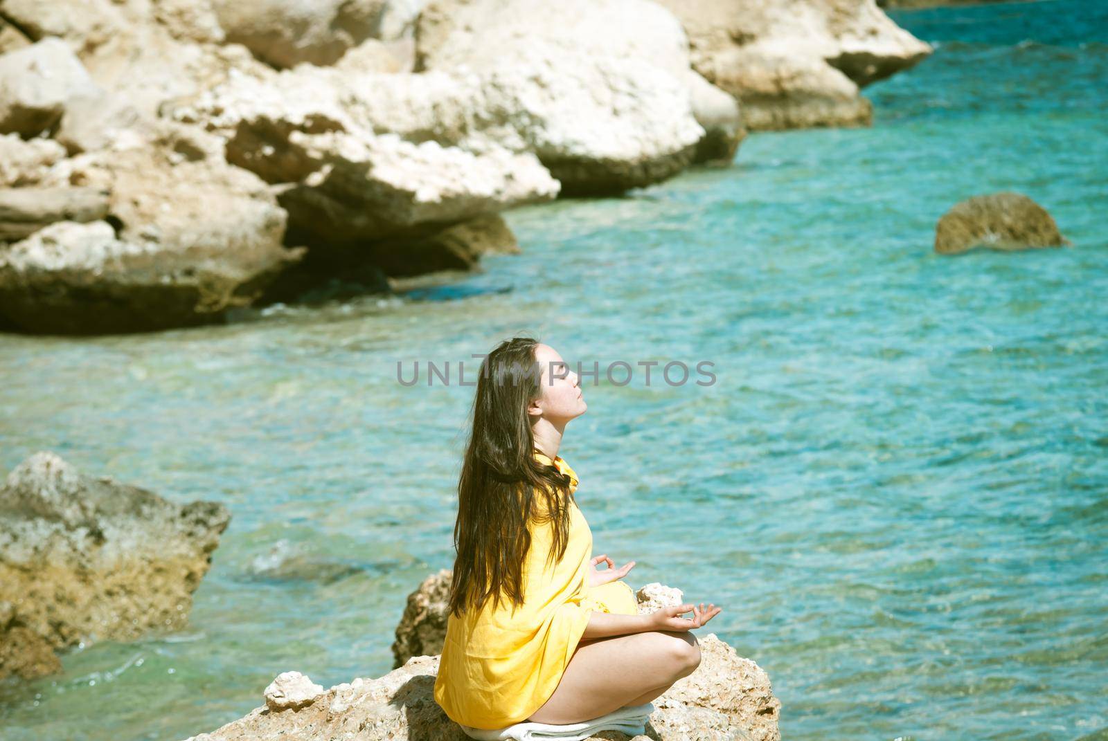 young woman meditating at sea backgroung by maramorosz