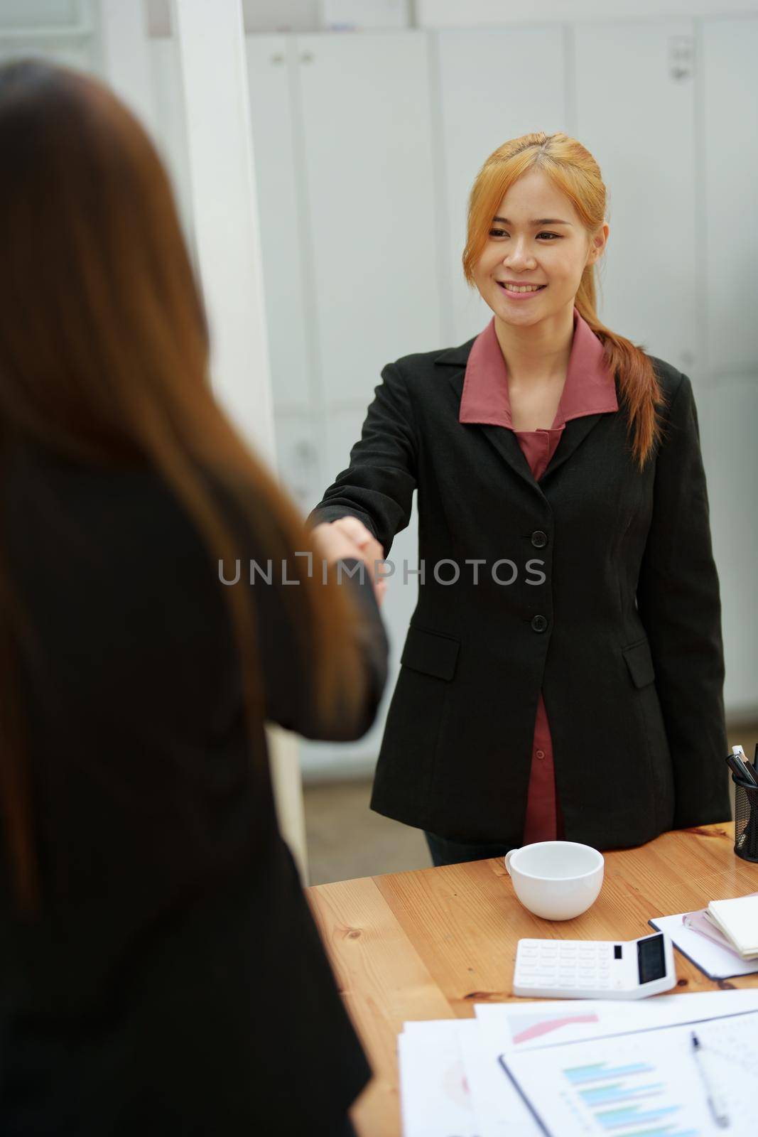 business merger, Asian businesswoman shake hands at the conference room with showcase their collaboration to strengthen their marketing efforts