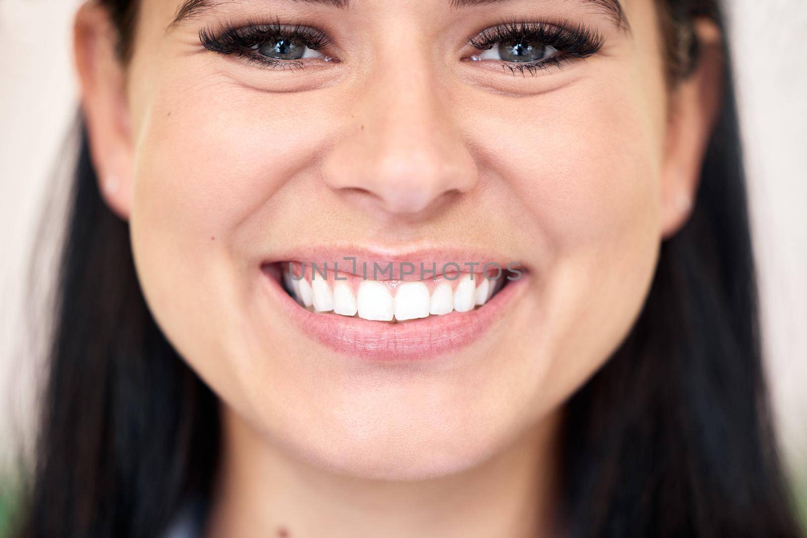 Closeup of a confident young caucasian woman with a bright and beautiful smile. One female only looking happy and cheerful. Brush regularly for healthy teeth free of cavities and gum disease.