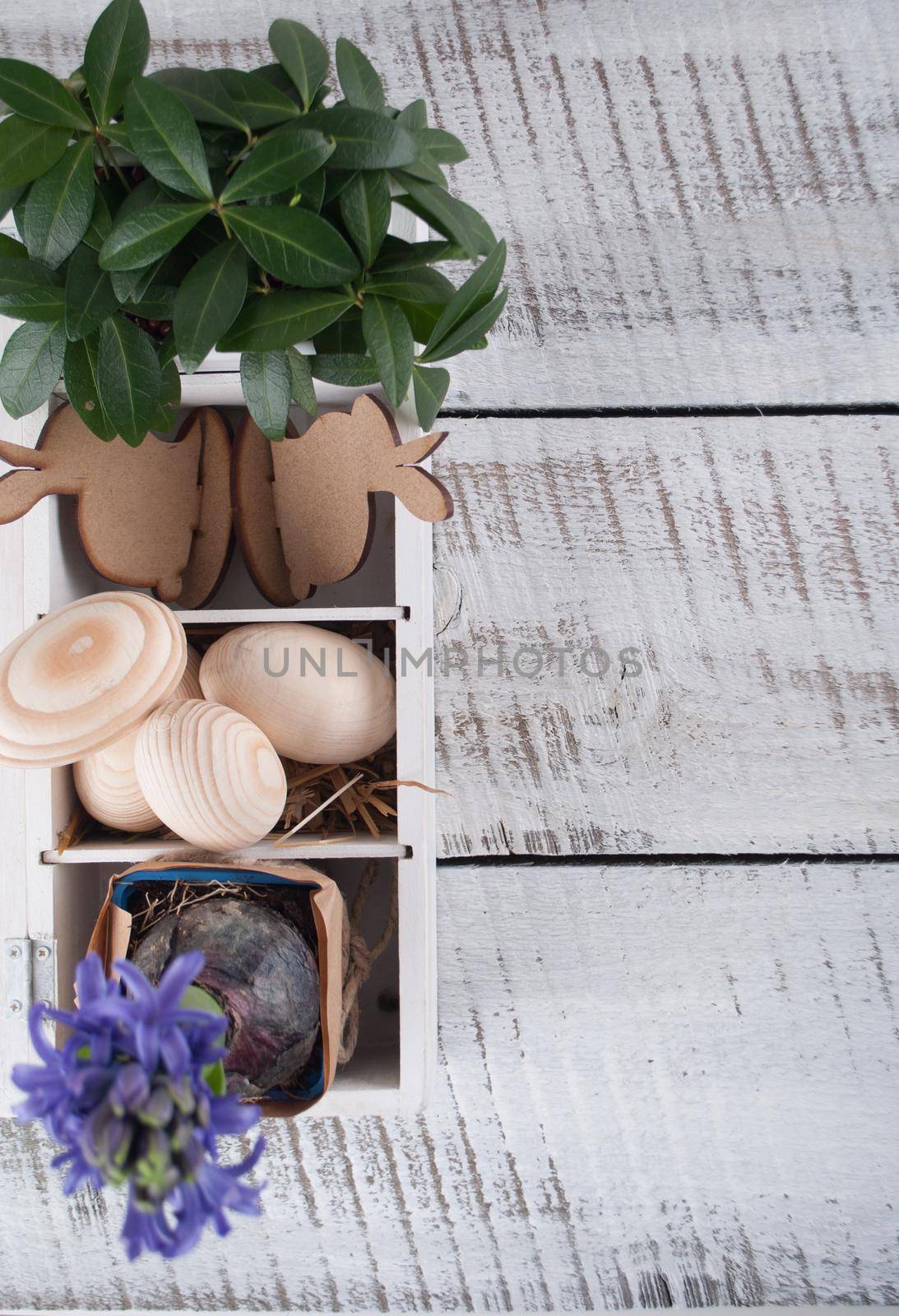 Easter decoration with wooden eggs, rabitts and flowers in box