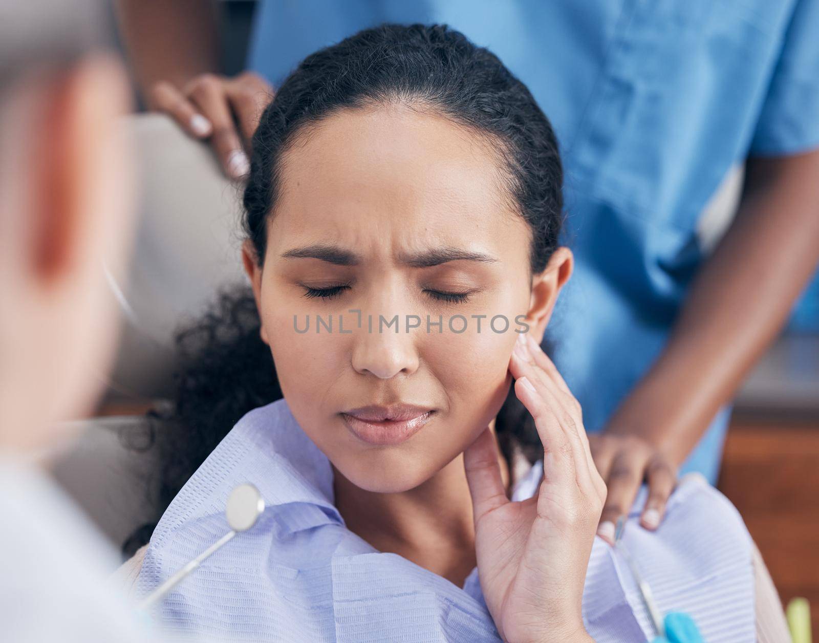 a young woman in pain at her dentists office.