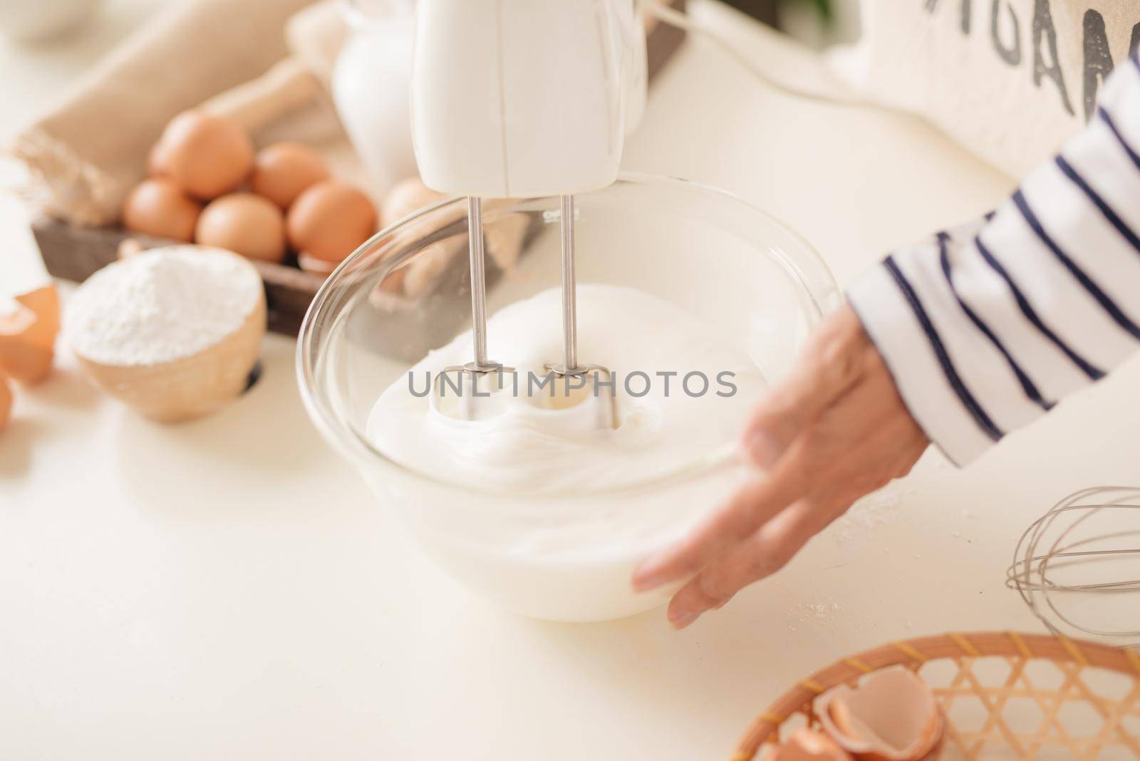 Mixing white egg cream in bowl with motor mixer, baking cake  by makidotvn