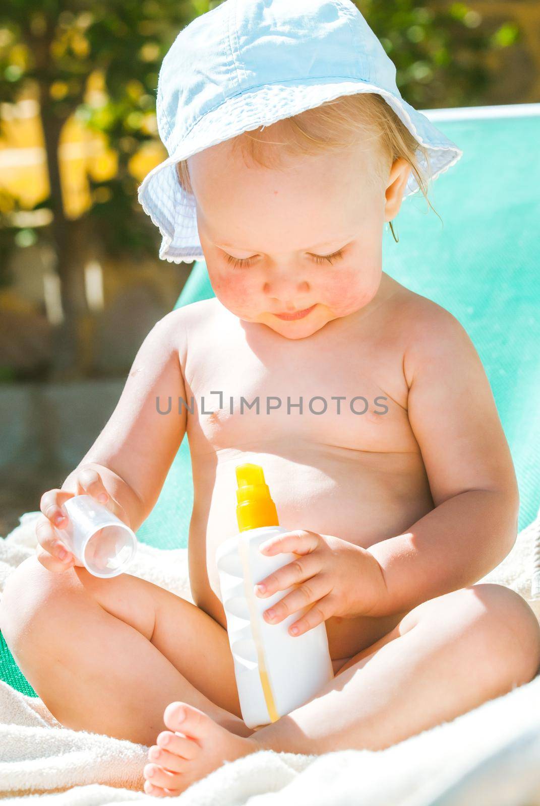 a child on the beach applies sunscreen. High quality photo