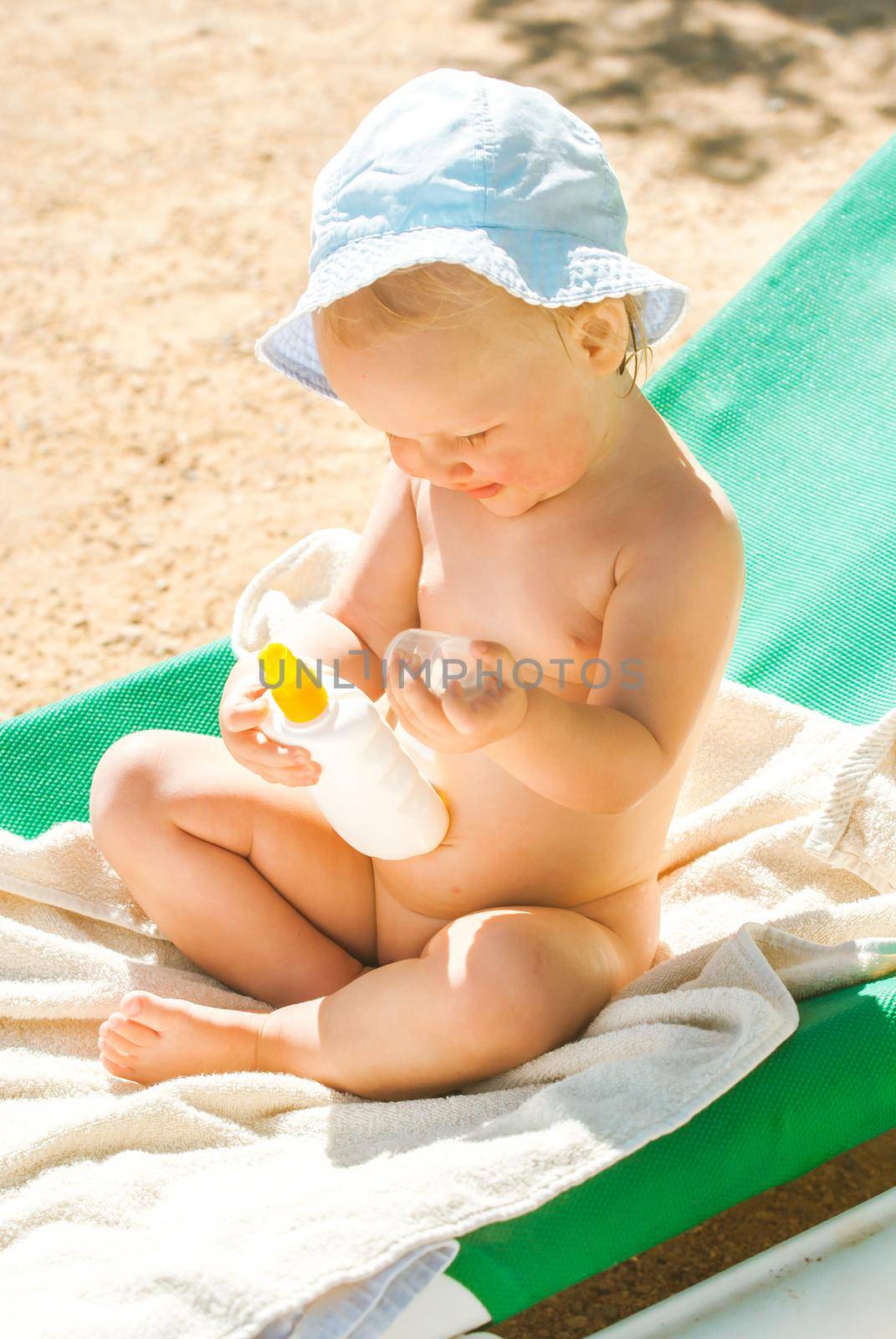 a child on the beach applies sunscreen. High quality photo