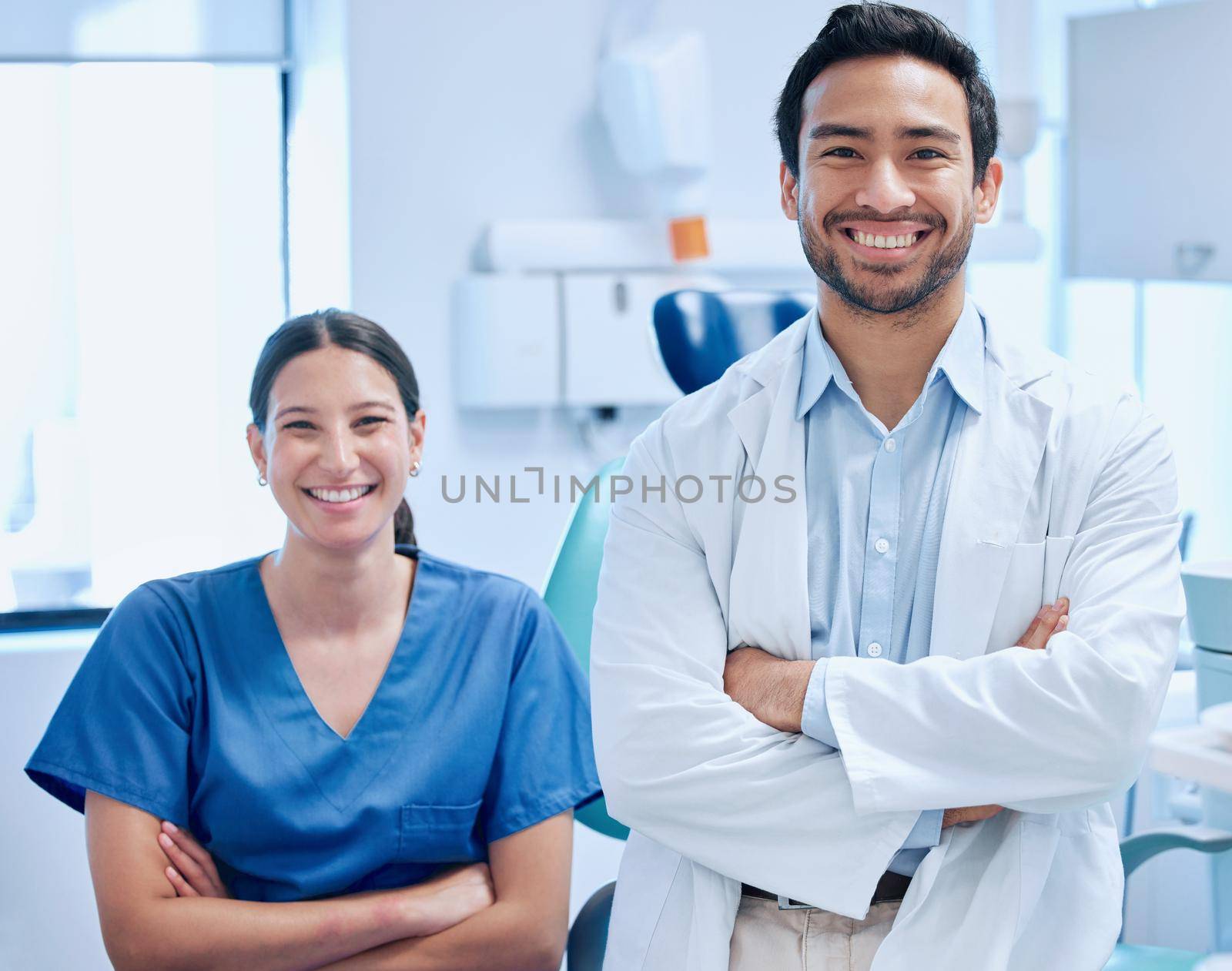 Lets get you smiling again. a young dentist with his nurse together in their office. by YuriArcurs