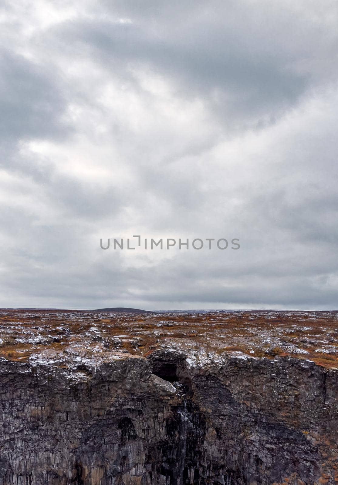 Walls surrounding spectacular Asbyrgi canyon waterfall under cloudy sky by FerradalFCG