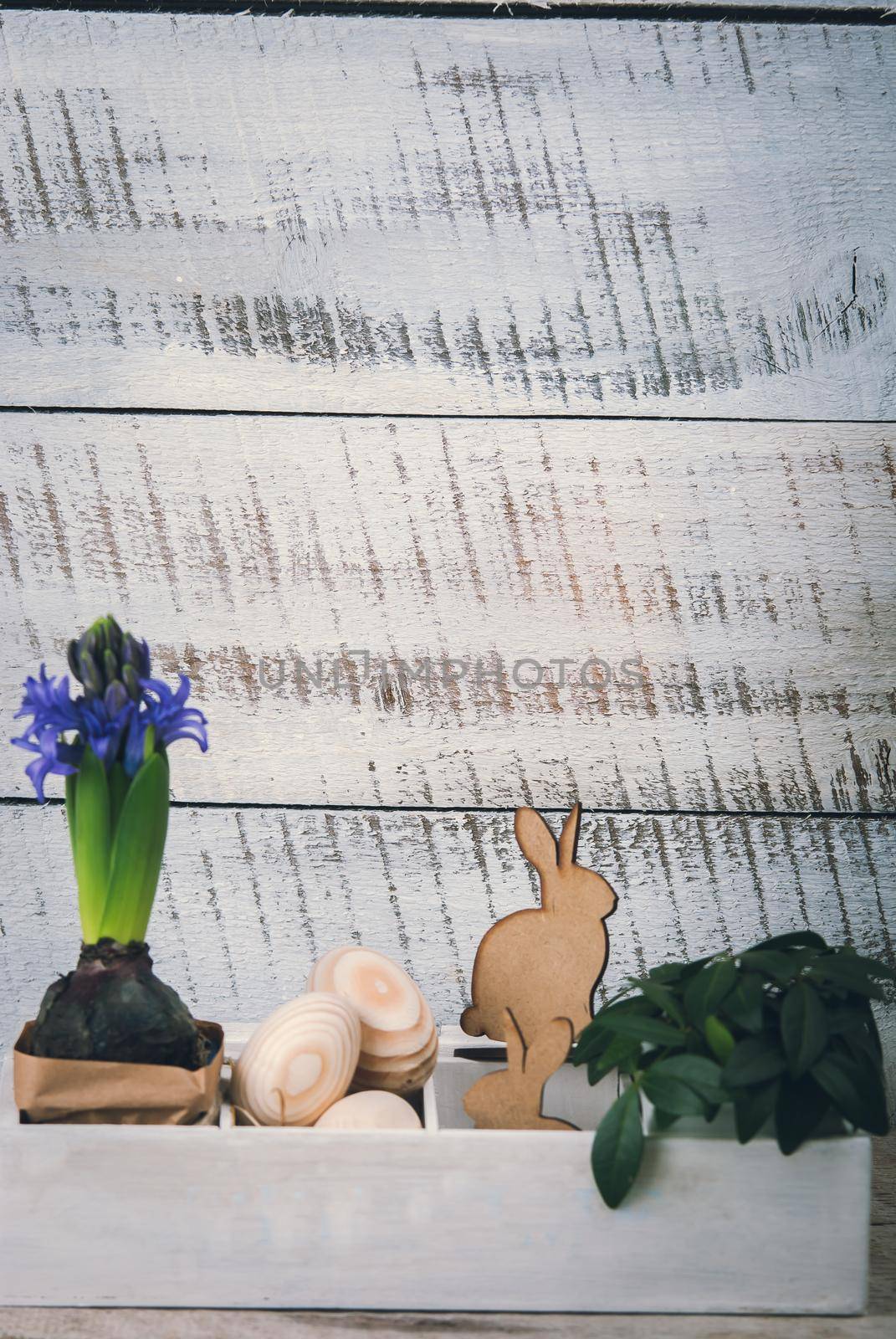 Easter decoration with wooden eggs, rabitts and flowers in box