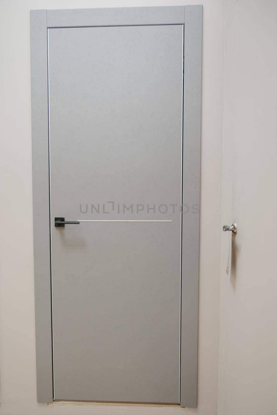 Modern wooden gray door with metal door handle.Stainless steel door handle.Interior design concept.Entrance door