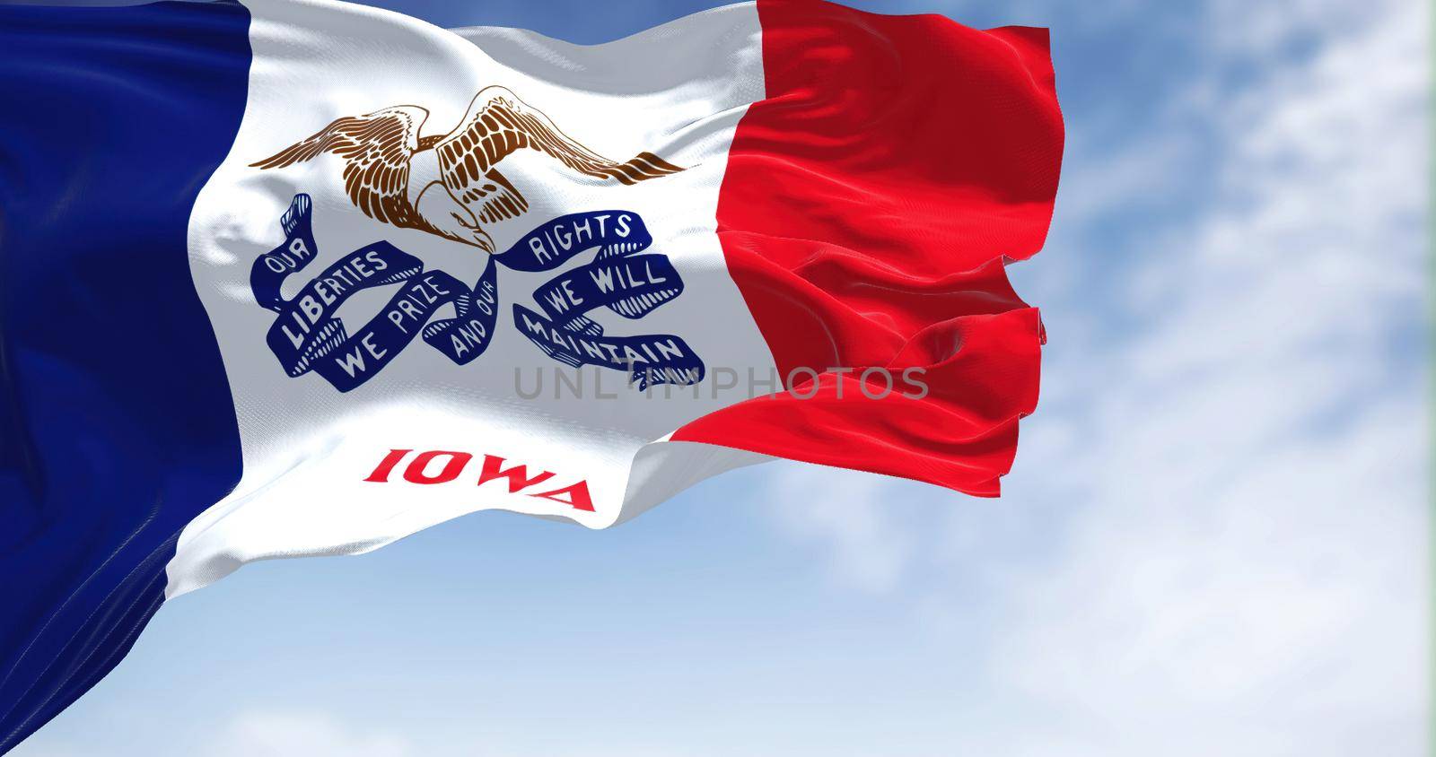 the flag of Iowa waving in the wind on a clear day by rarrarorro