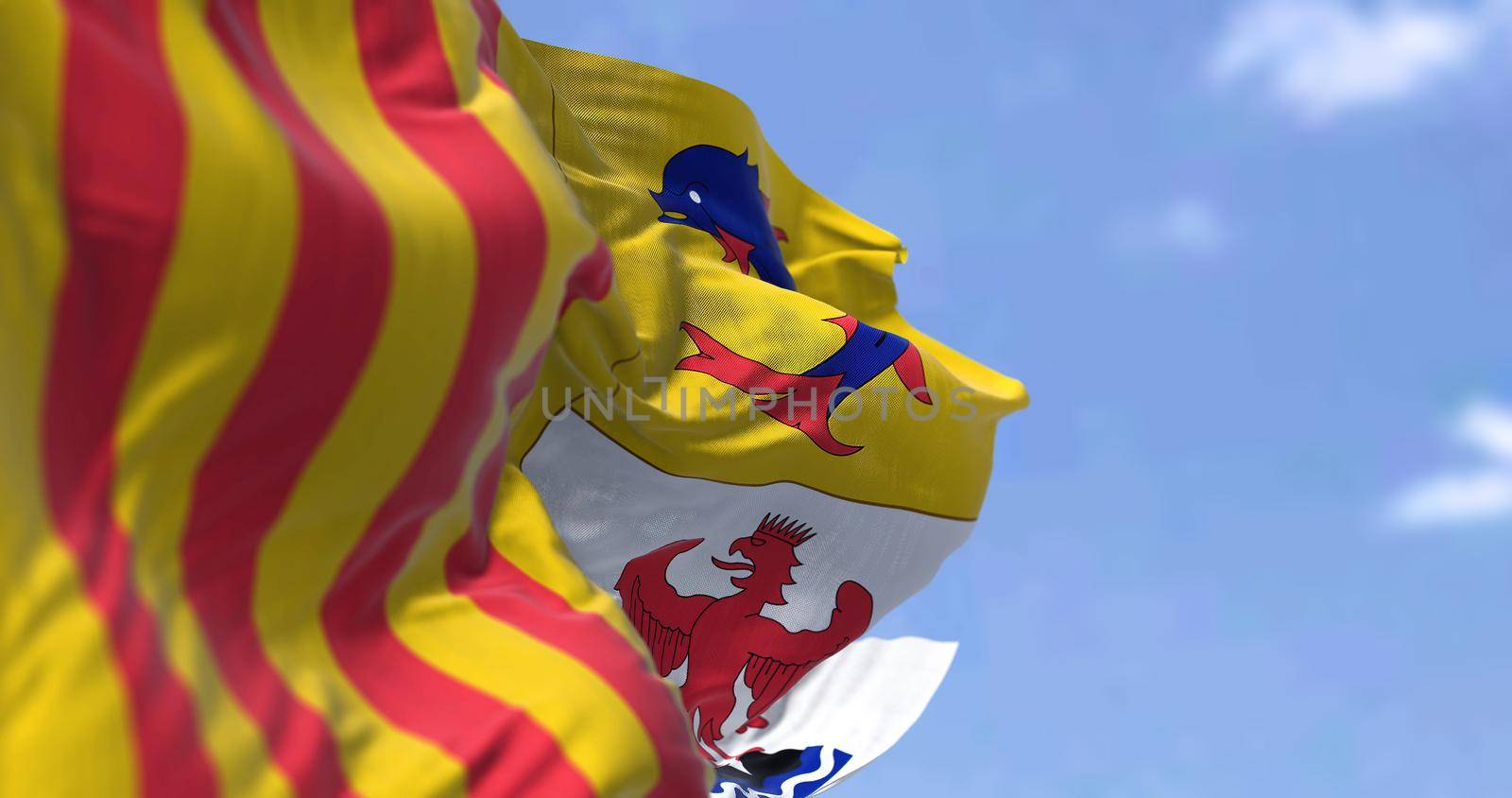 The region flag of Provence-Alpes-Côte d'Azur waving in the wind on a clear day. Provence-Alpes-Côte d'Azur is one of the eighteen administrative regions of France