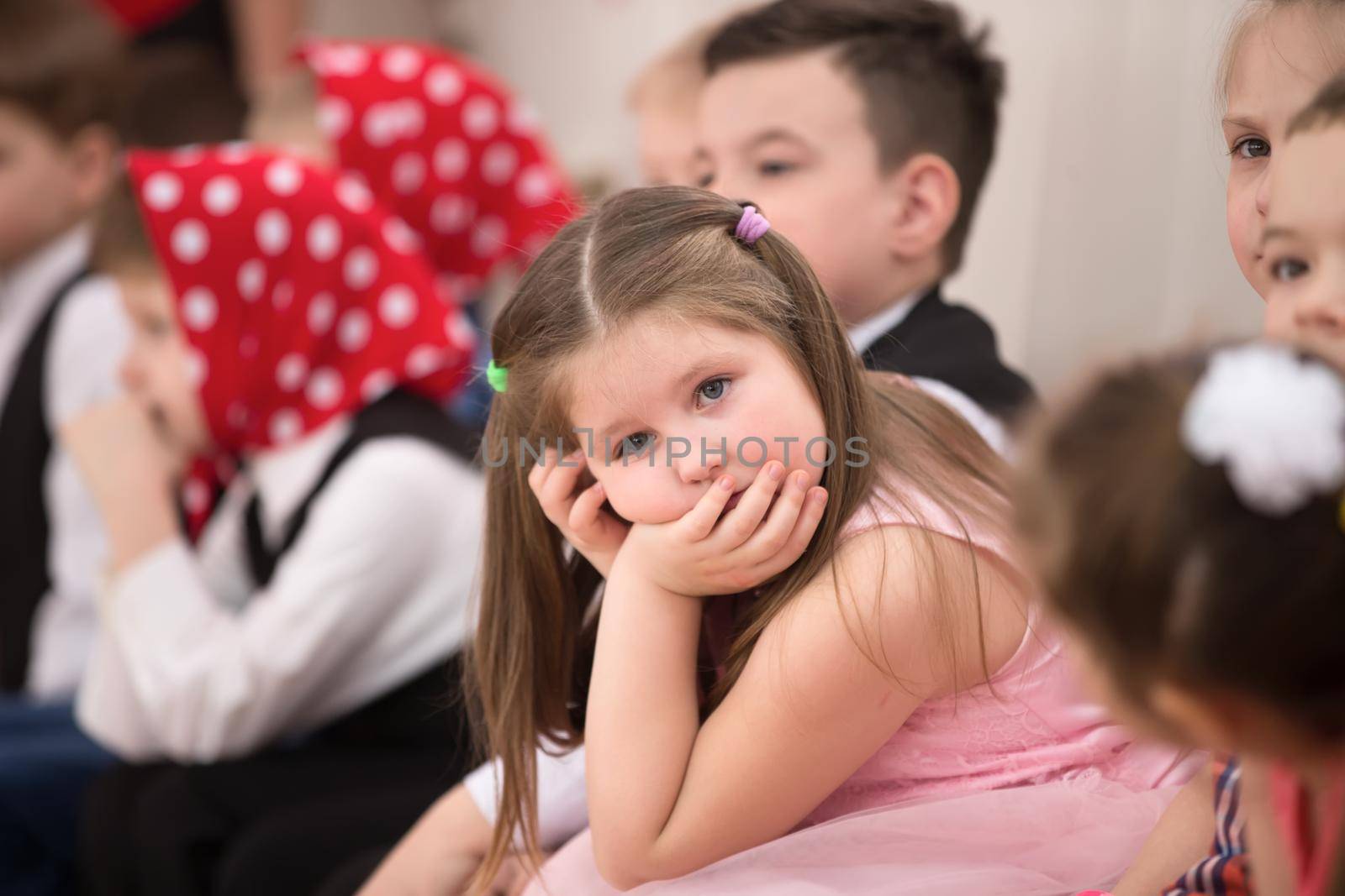 Belarus, Gomel, 6 March 2018. Kindergarten is the fifth. Children's holiday matinee.A boring and sad little girl on holiday.Bored Spectator