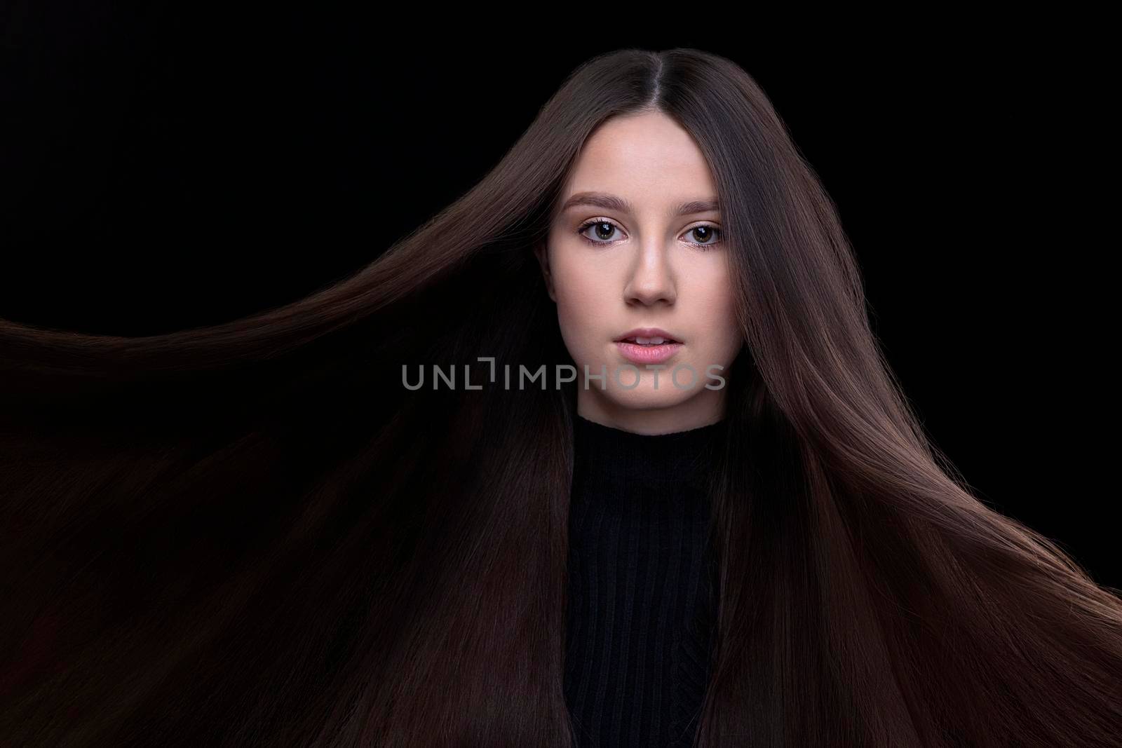 A beautiful young girl with natural beauty with long smooth hair on a dark background. by Sviatlana