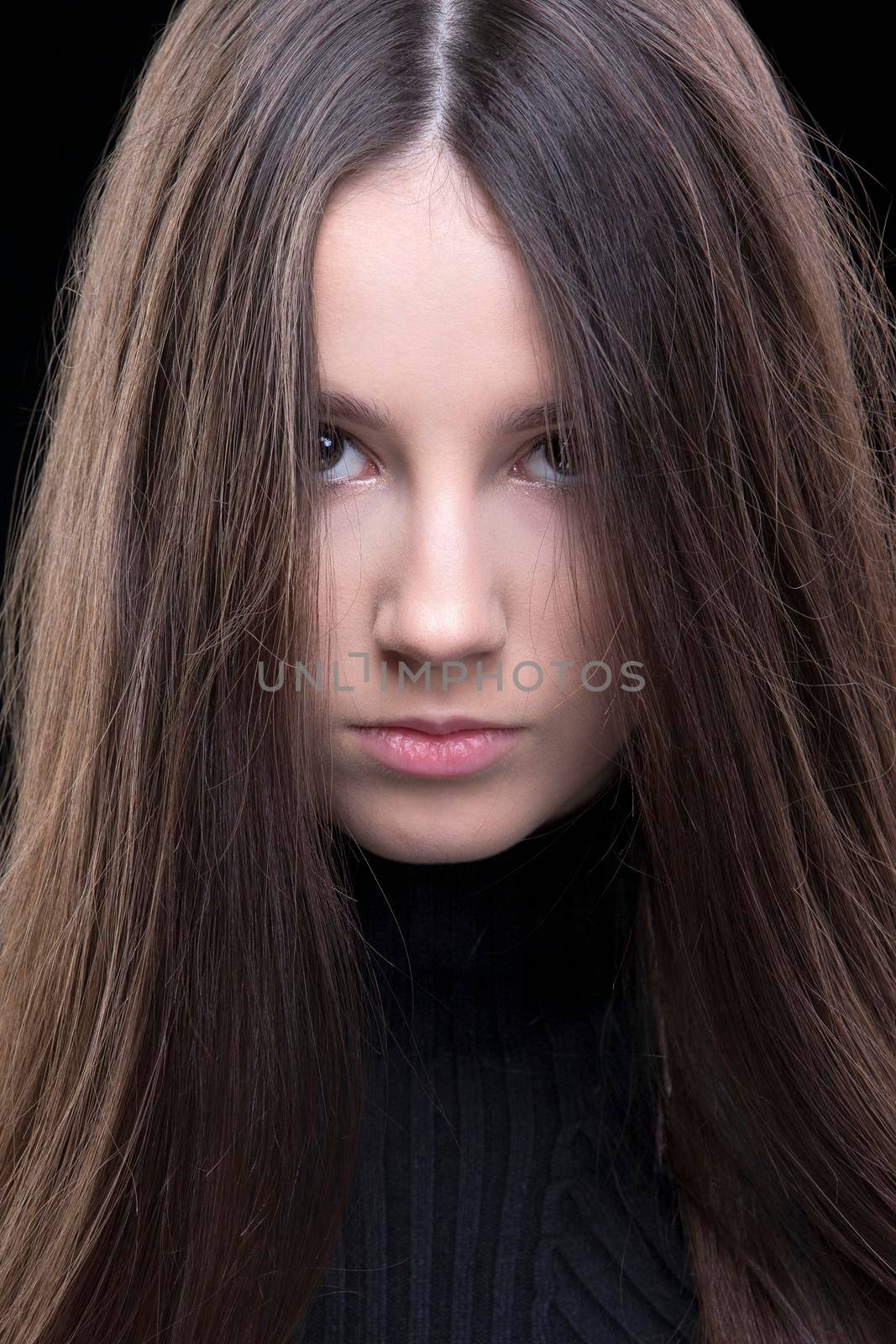 A beautiful brunette girl looks angrily into the camera.