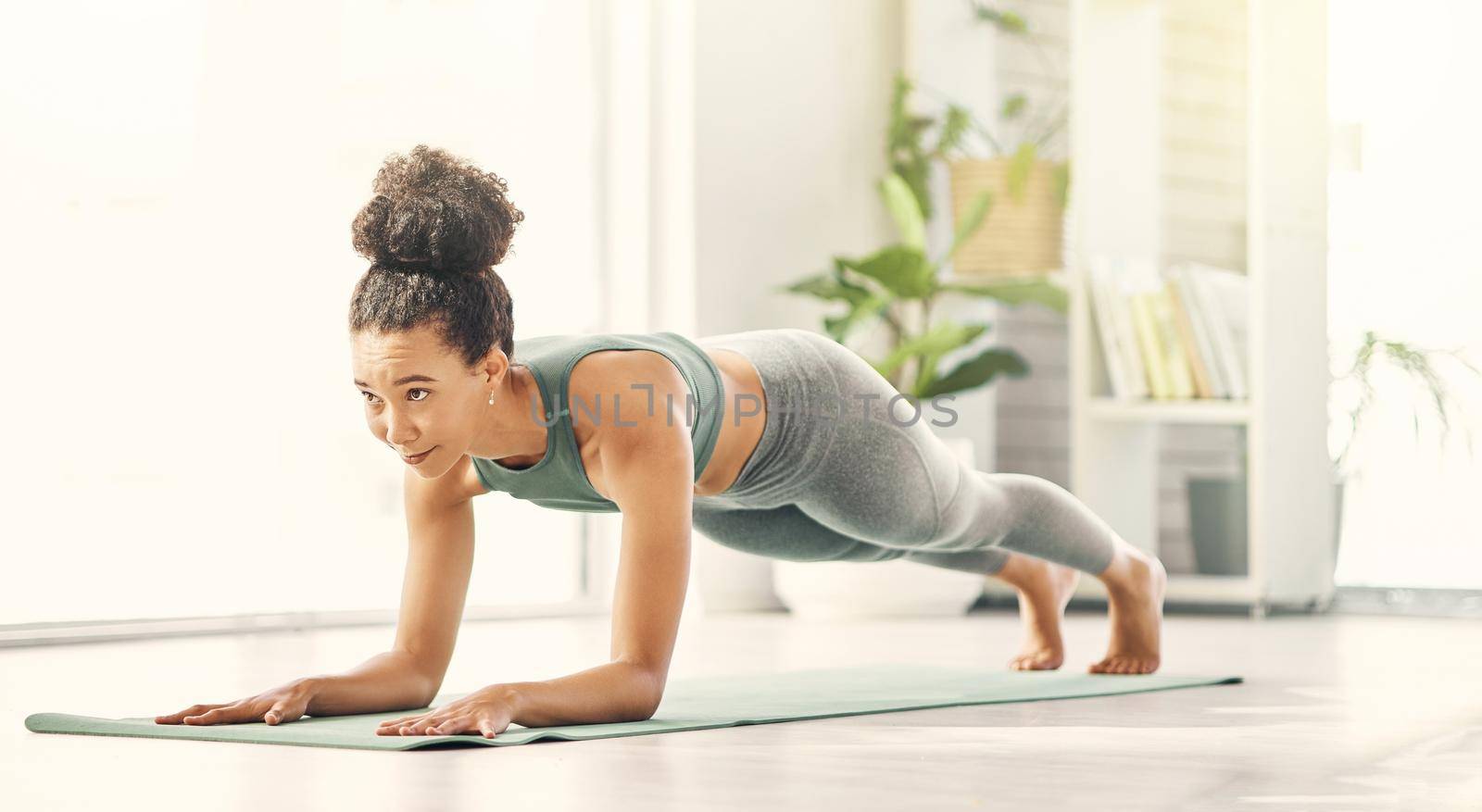 a young woman in plank position on her exercise mat.