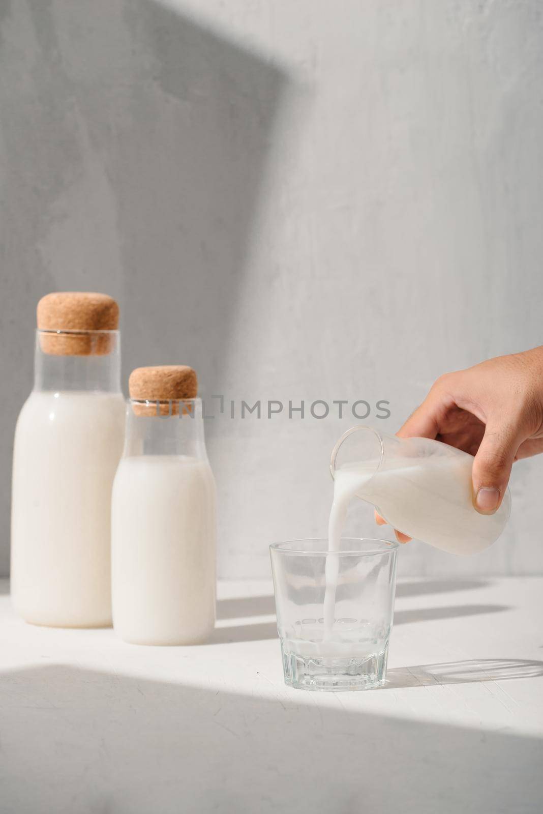 Milk from a jug pouring into glass by makidotvn