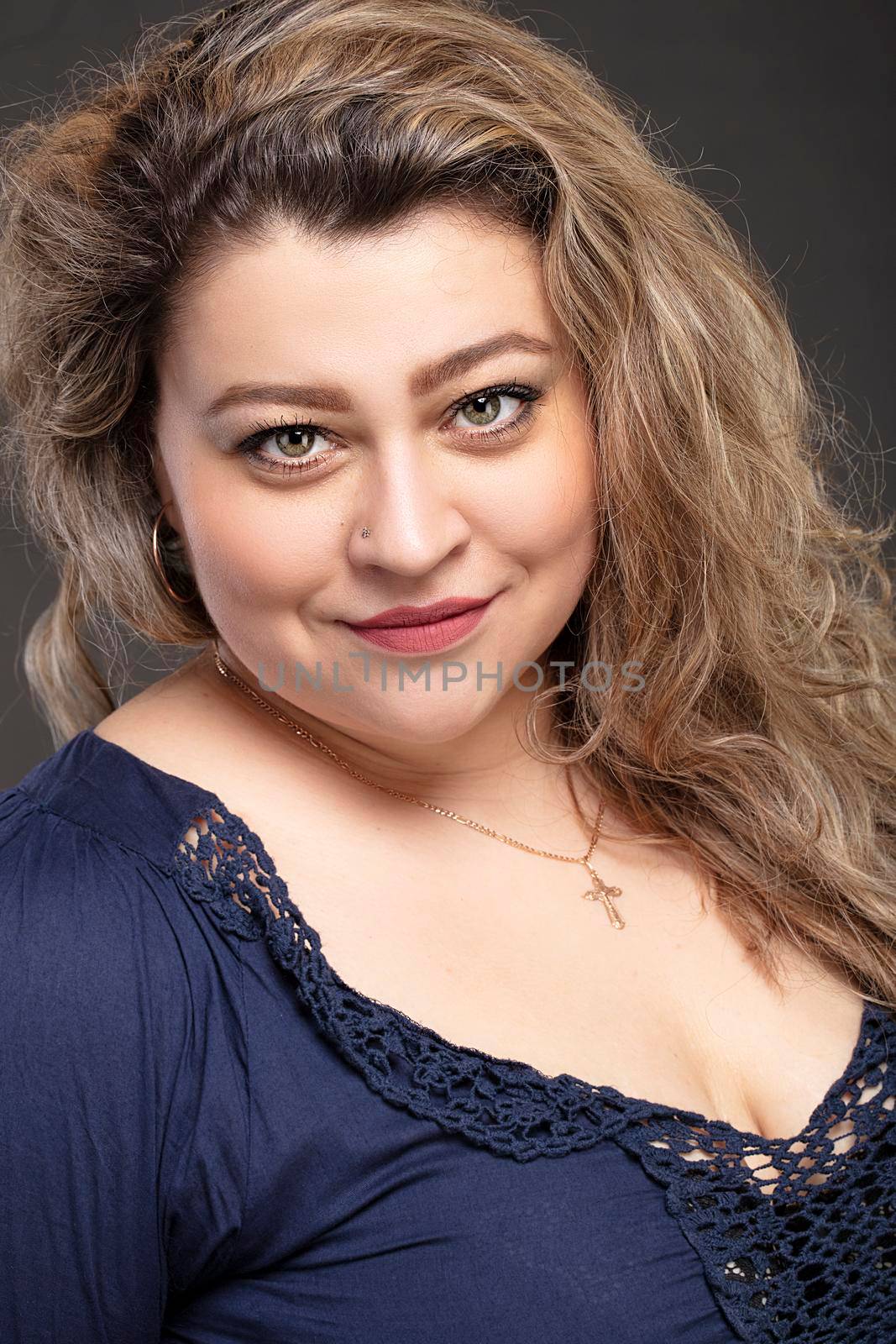 Portrait of a beautiful fat woman close-up on a gray background.