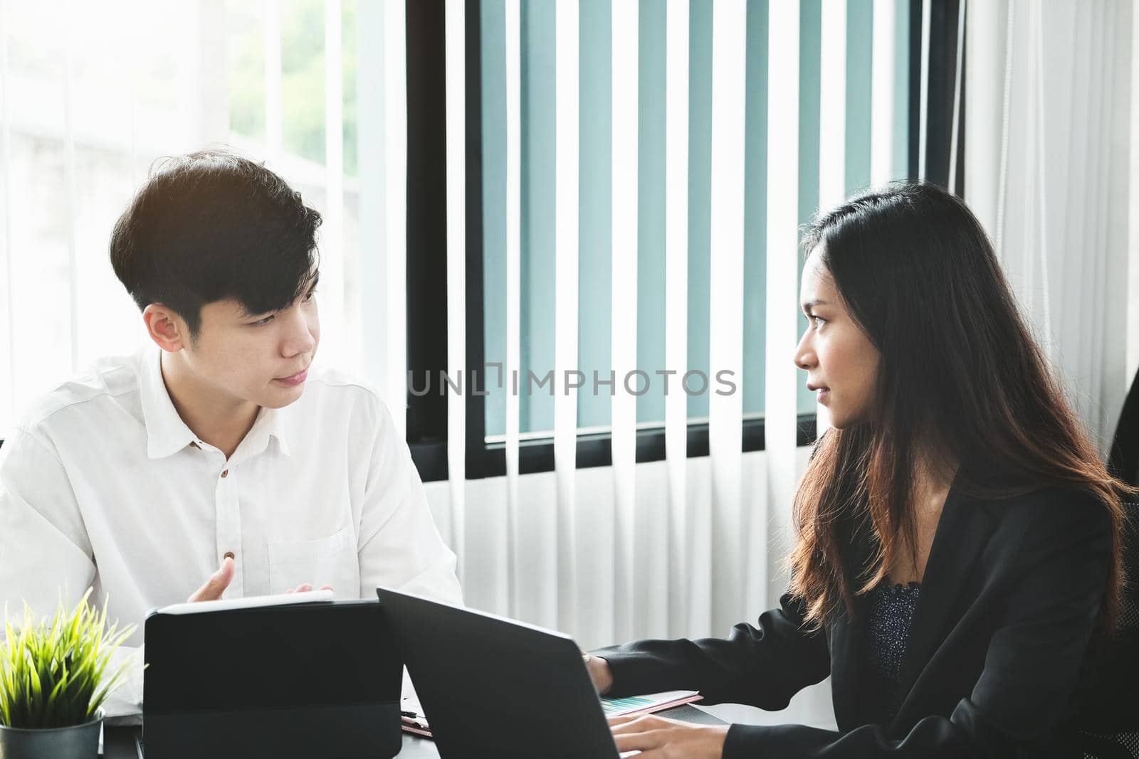 Two young business executives are discussing to change their business concept to increase profits and the strength of their business by Manastrong